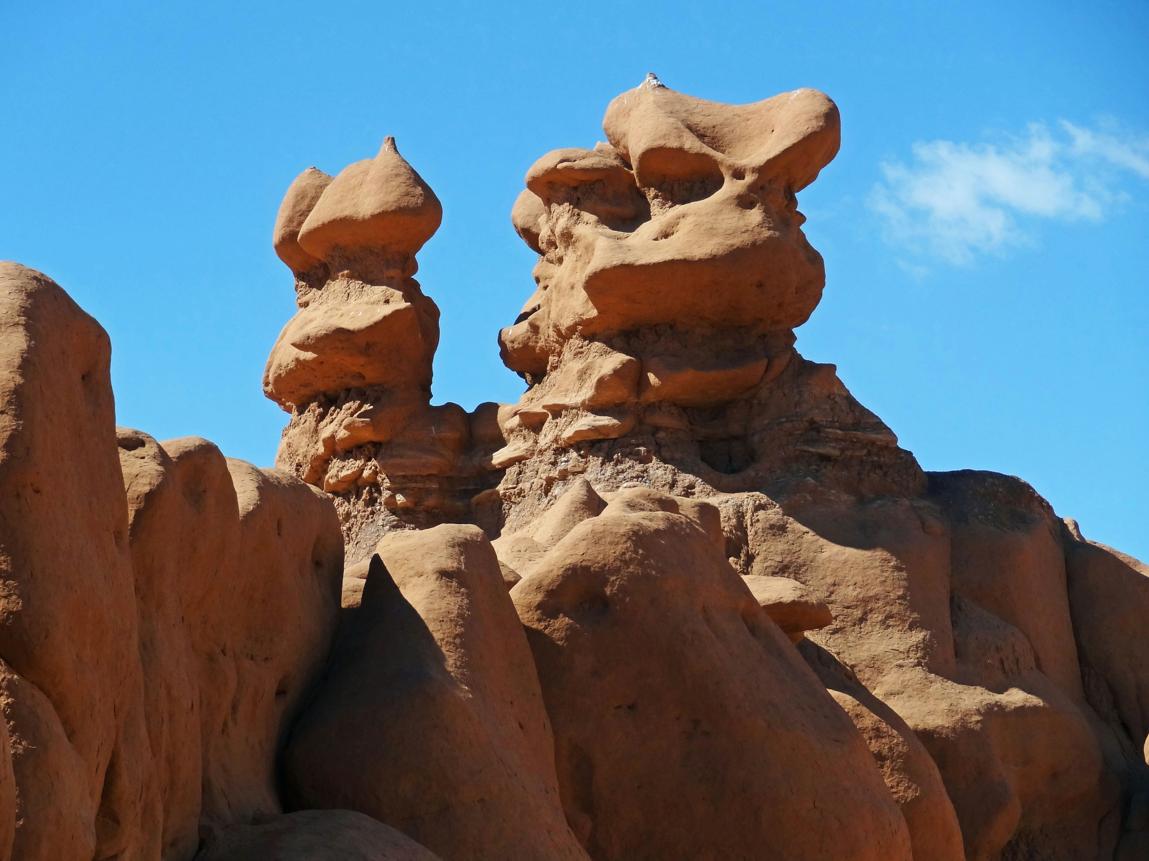 Unique red rock formations resembling sculptures against a blue sky