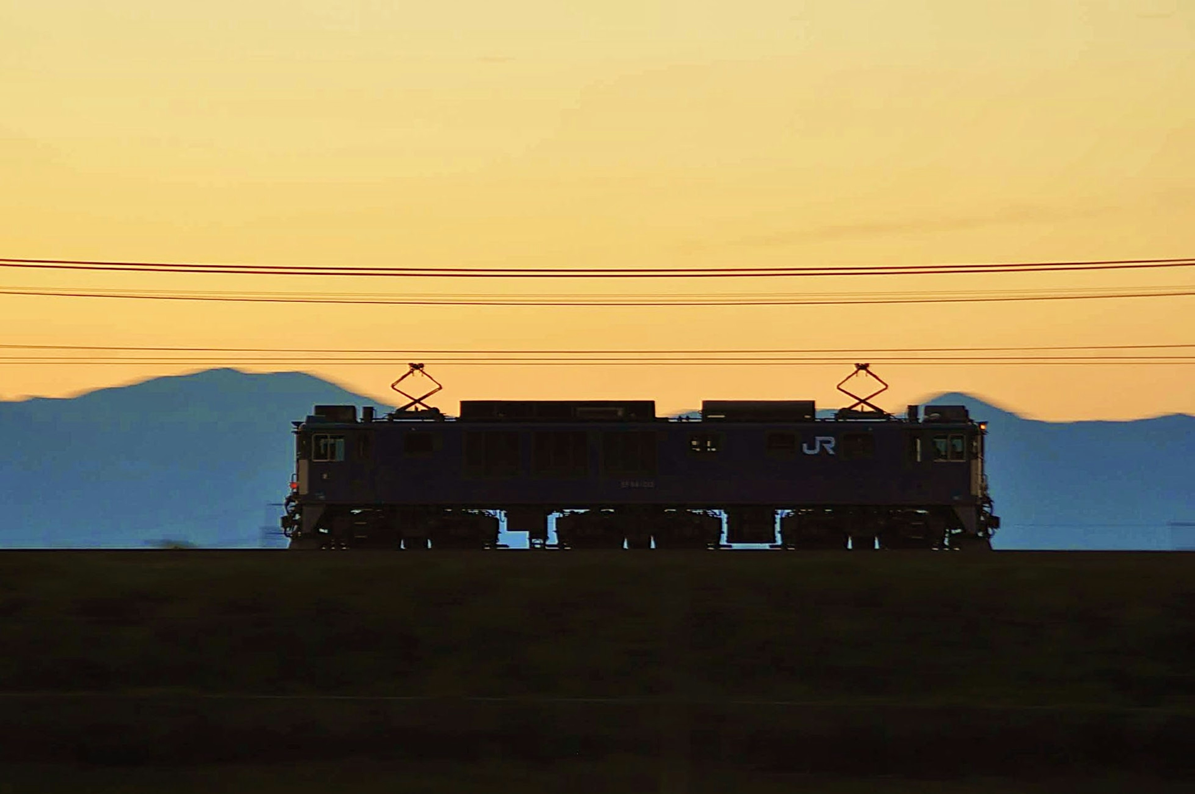 Silhouette d'un train contre un ciel de coucher de soleil