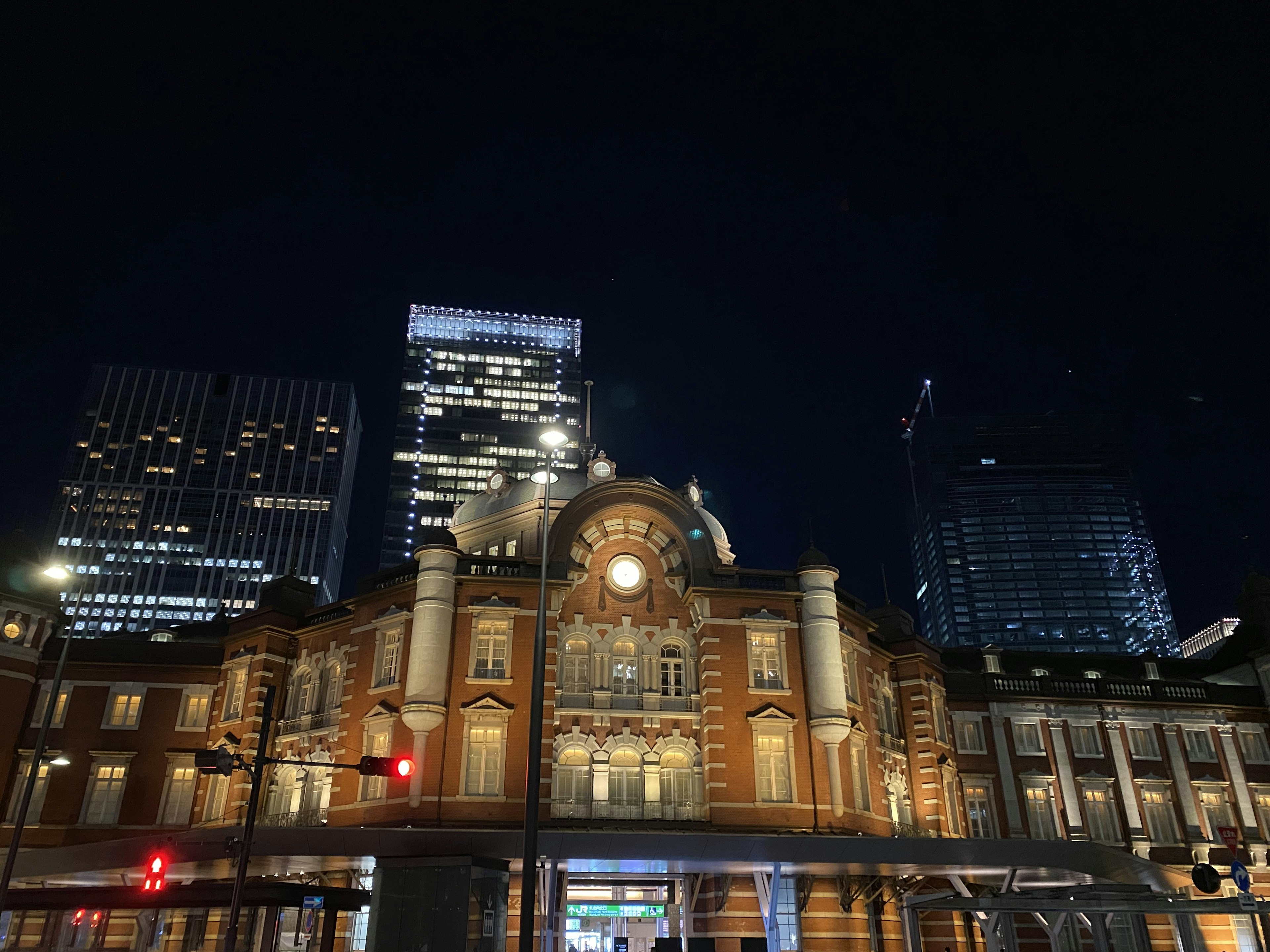 Beautiful exterior of Tokyo Station at night surrounded by skyscrapers