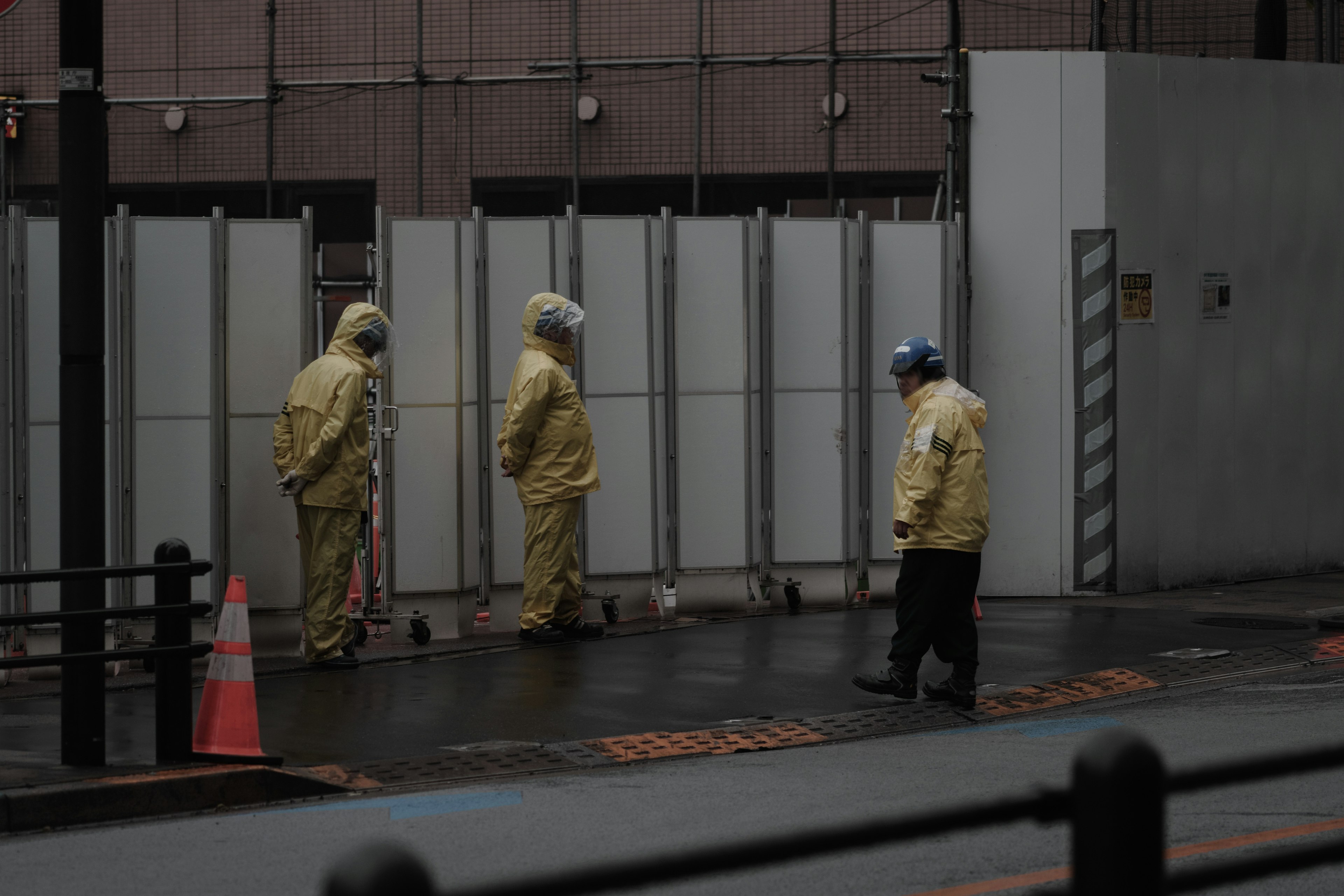 Workers in protective gear walking in the rain