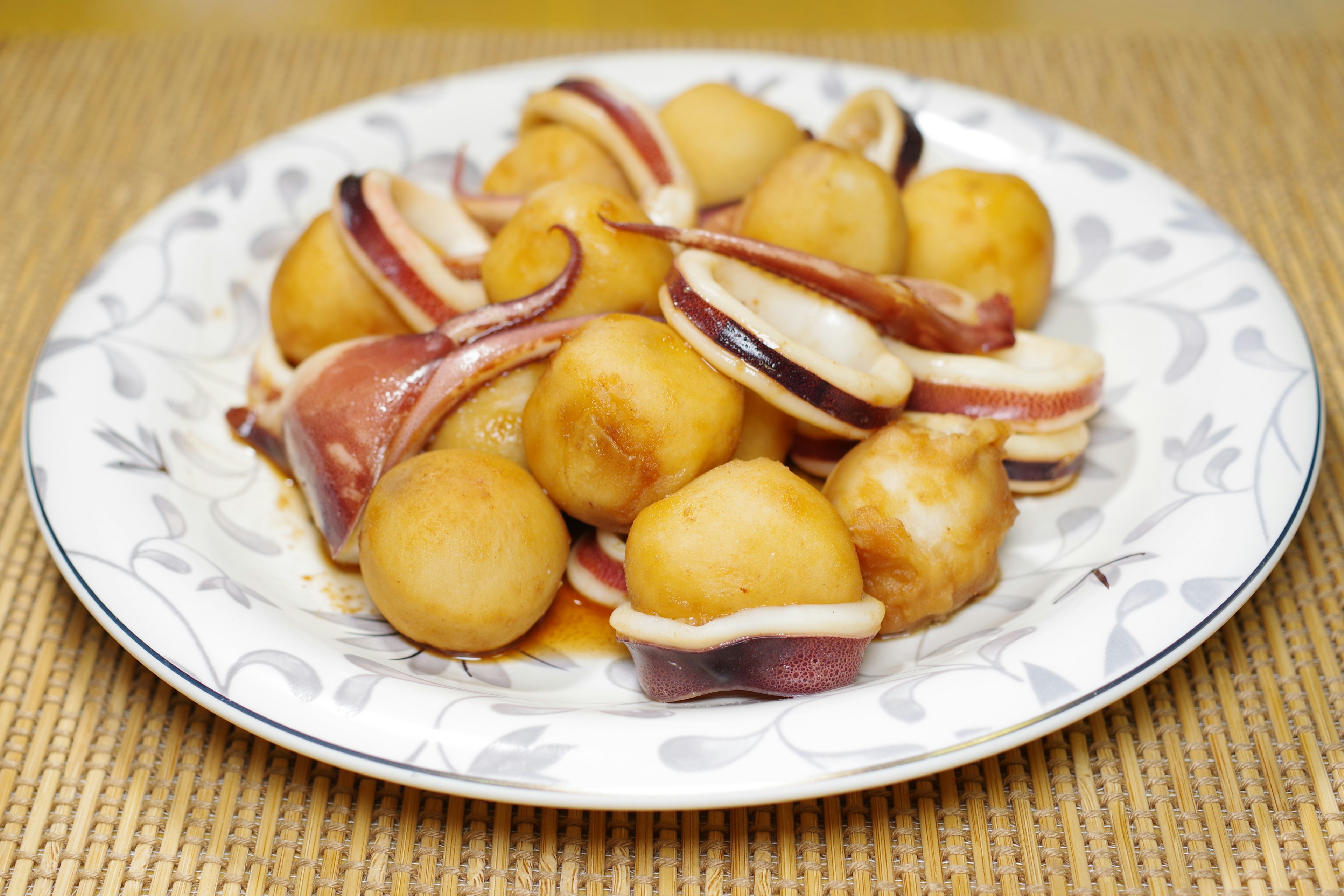 Dish of squid and potatoes served on a white plate