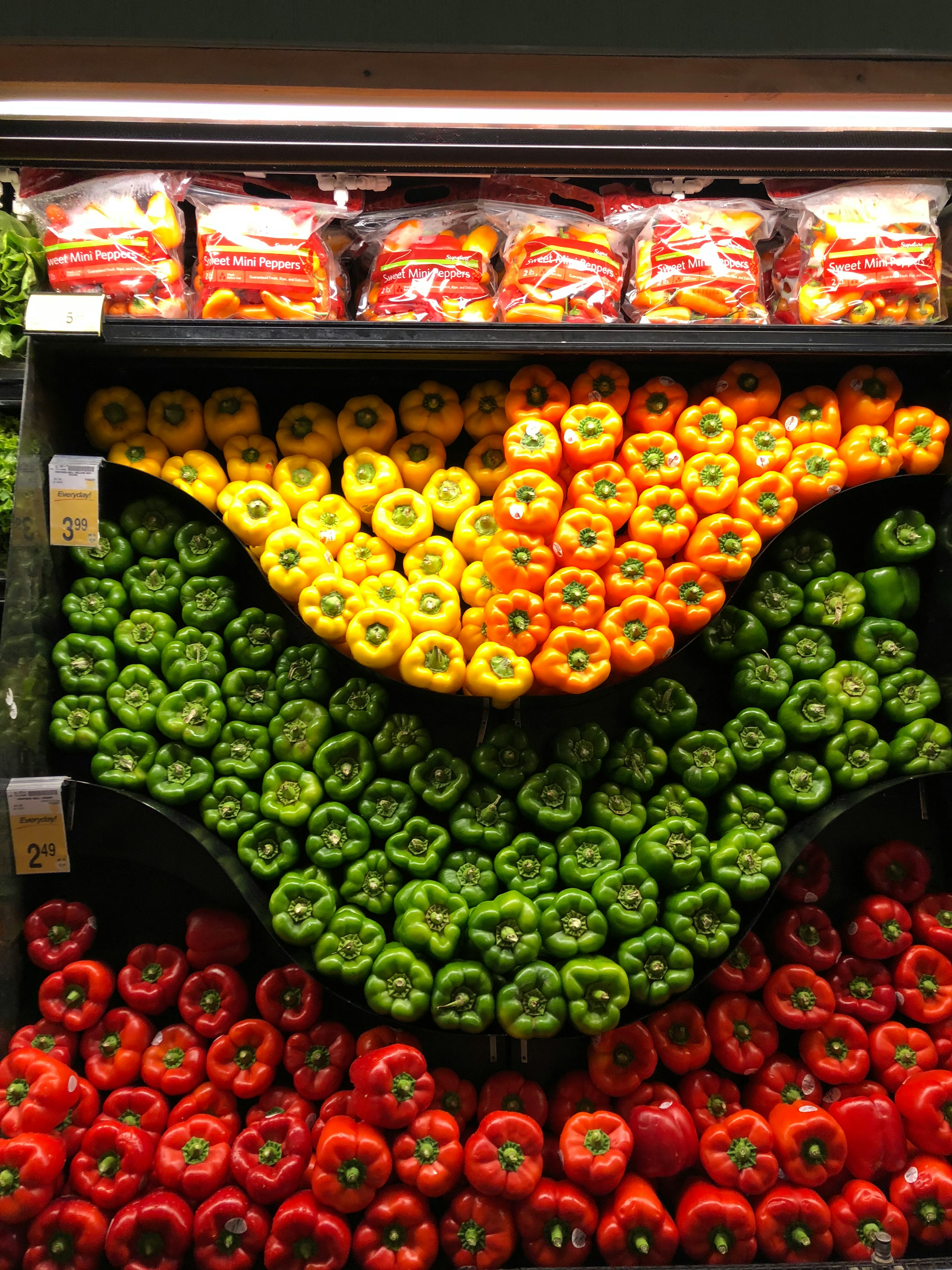 Poivrons colorés disposés dans une étagère de supermarché