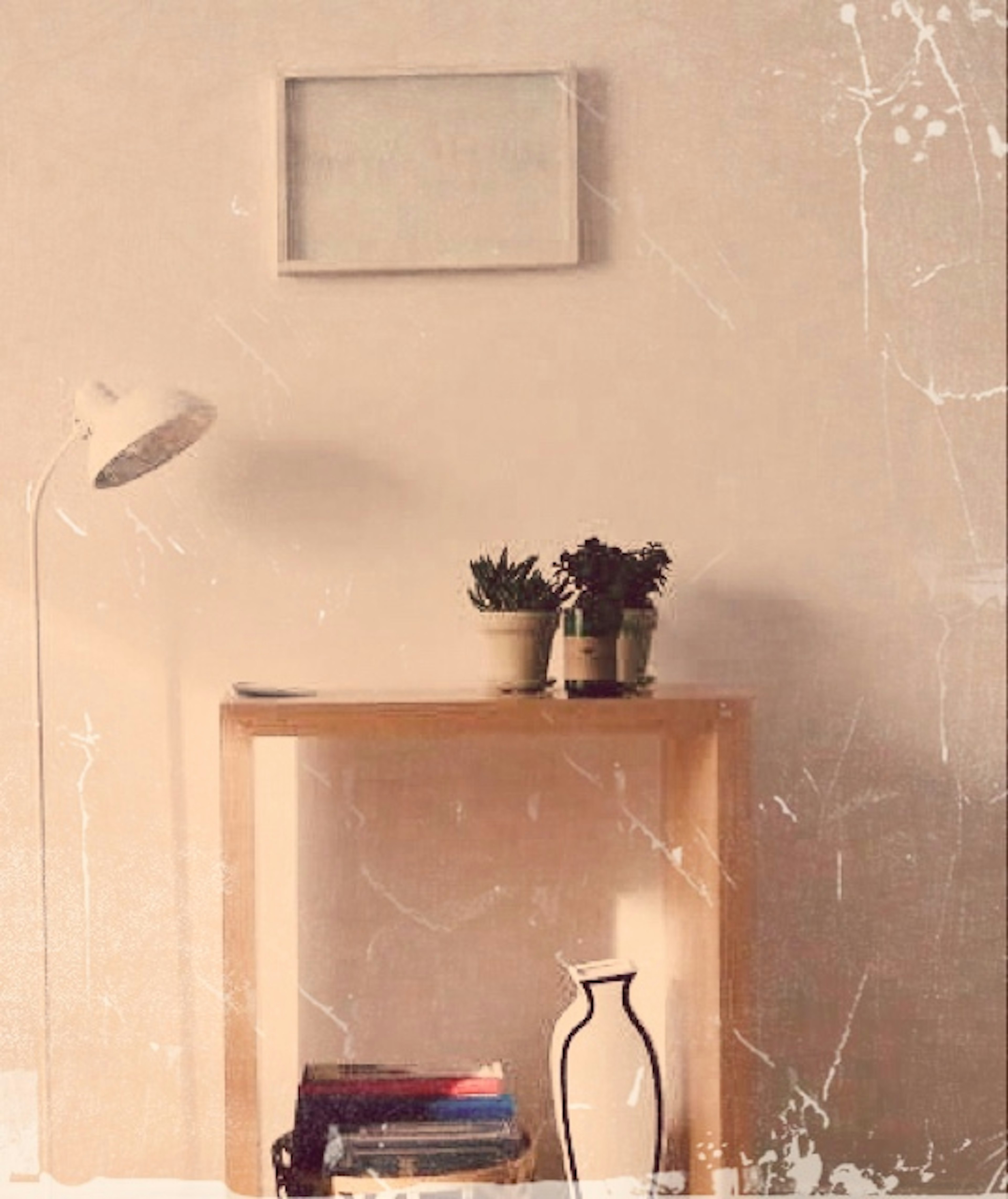 A corner of a room featuring simple furniture and potted plants