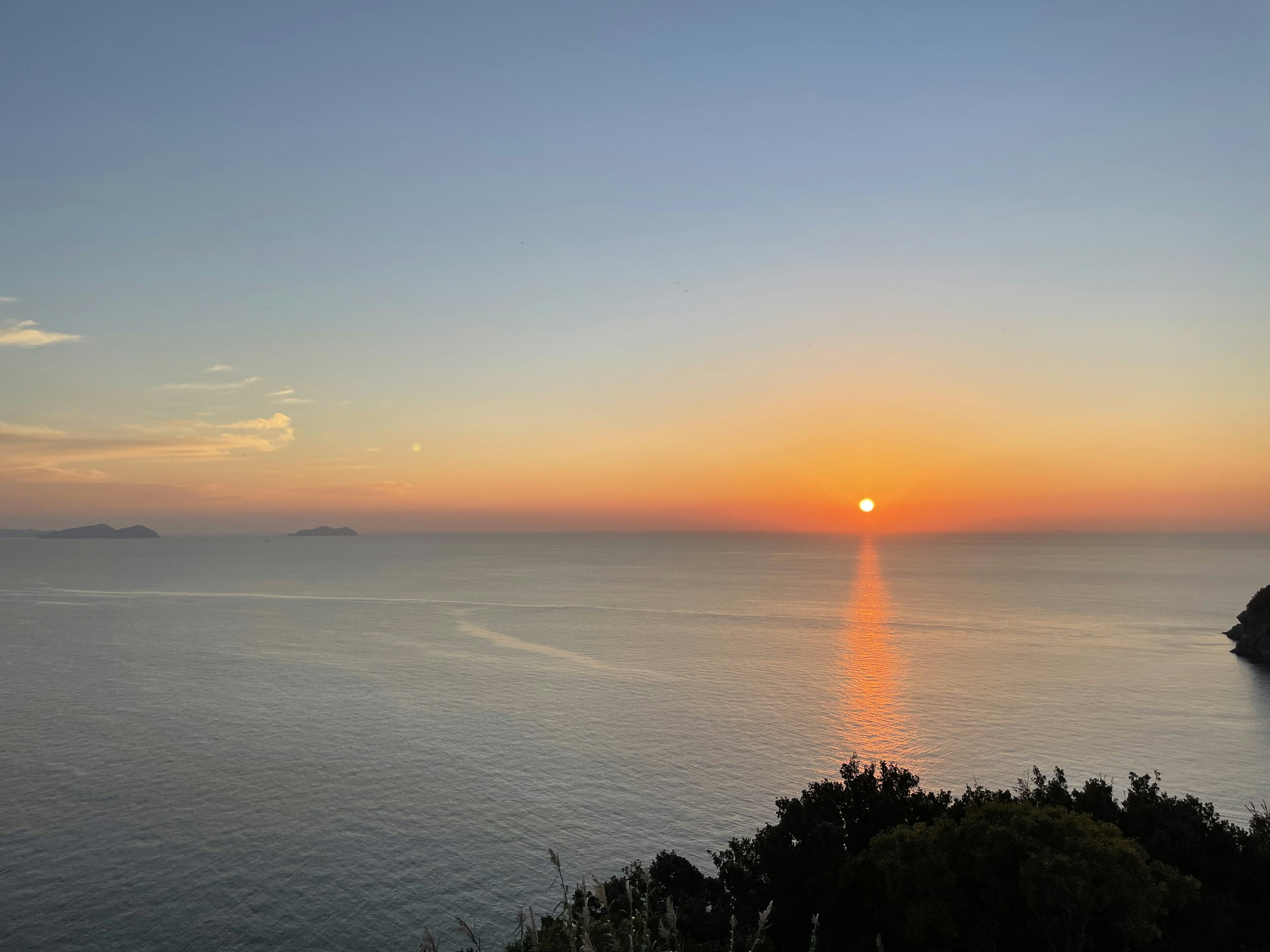 Ruhiger Sonnenuntergang über einem ruhigen Ozean mit wunderschönem Farbverlauf am Himmel