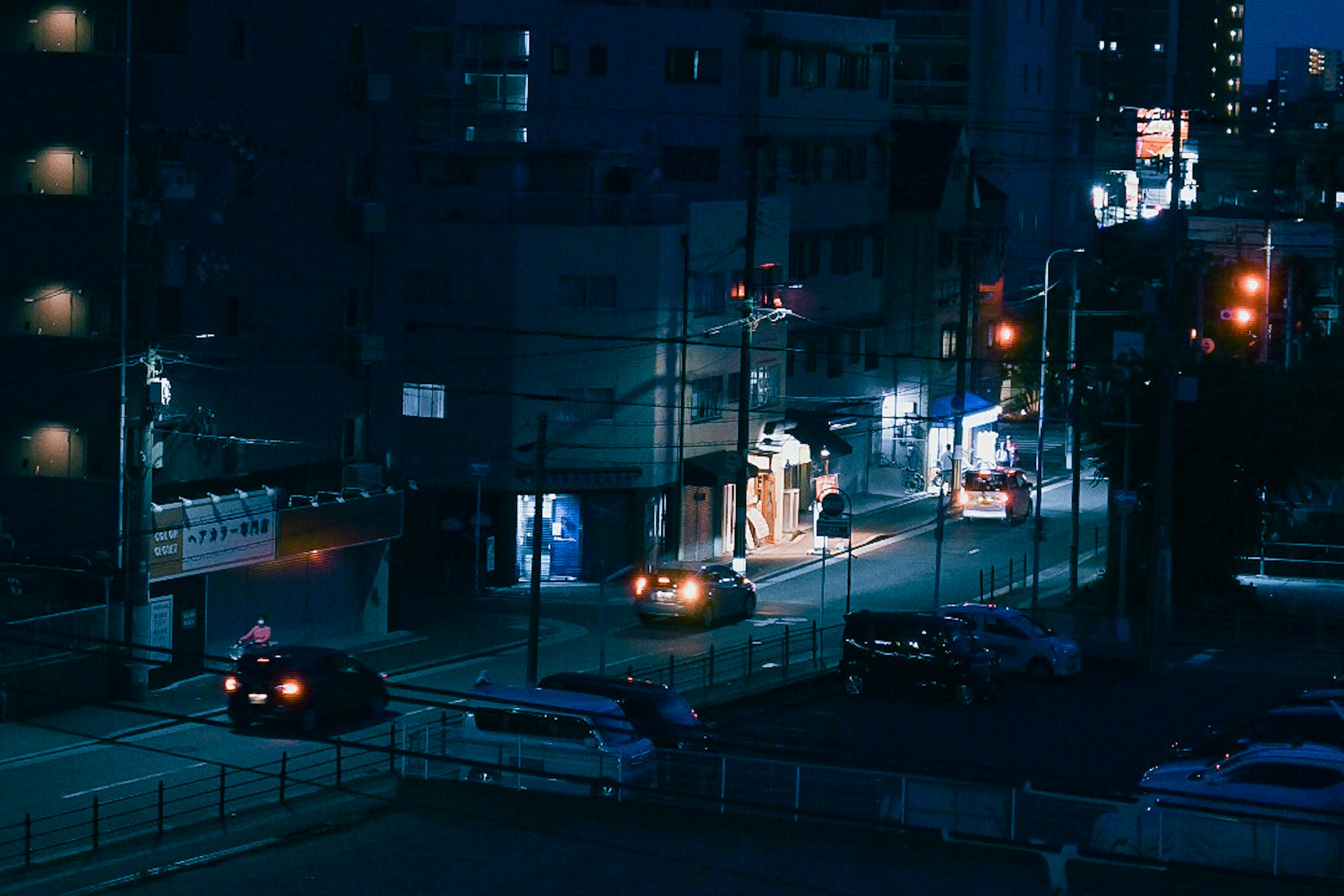 Paesaggio urbano notturno con edifici e automobili illuminate