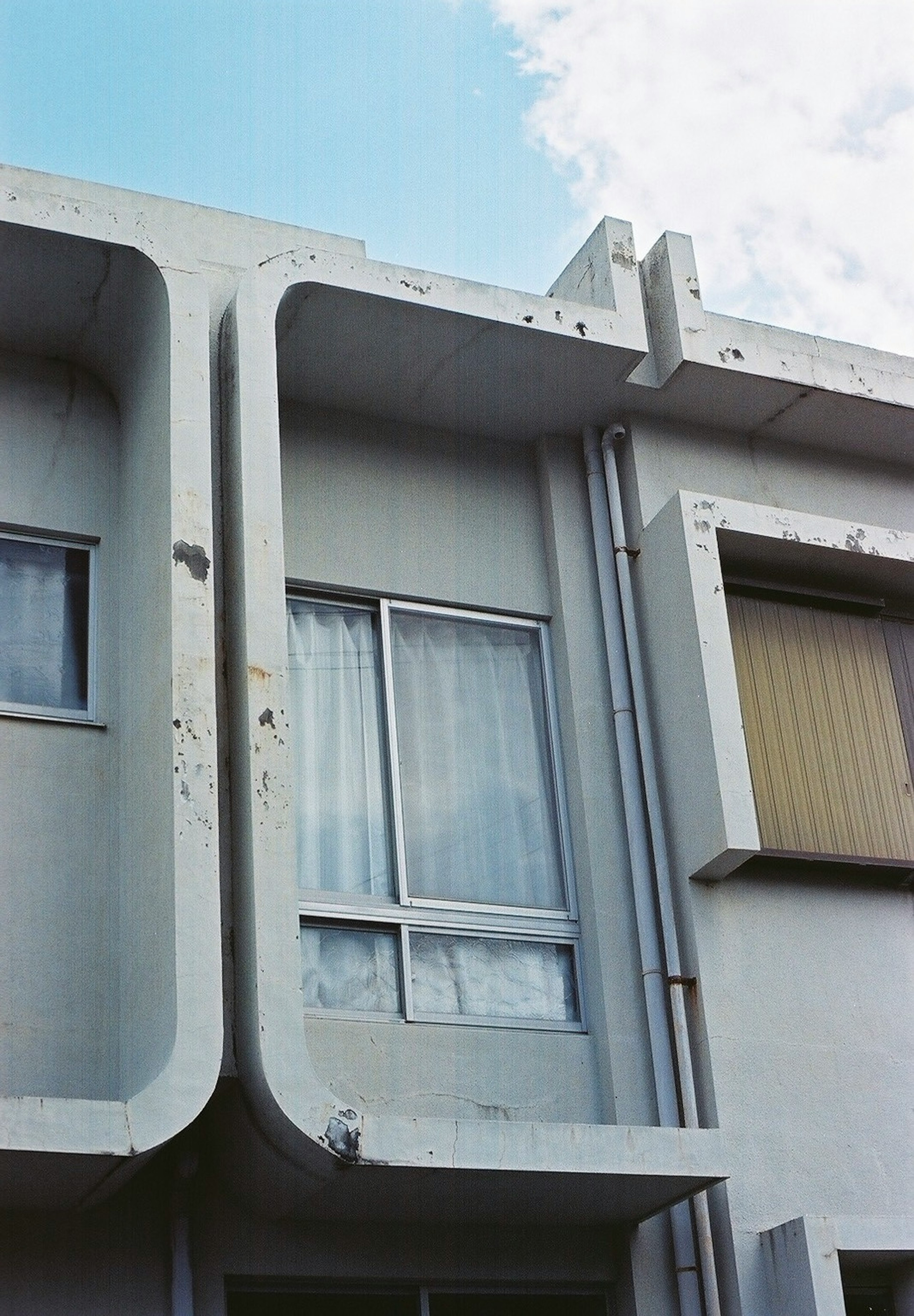 Partie d'un bâtiment moderne avec un extérieur blanc et une grande fenêtre