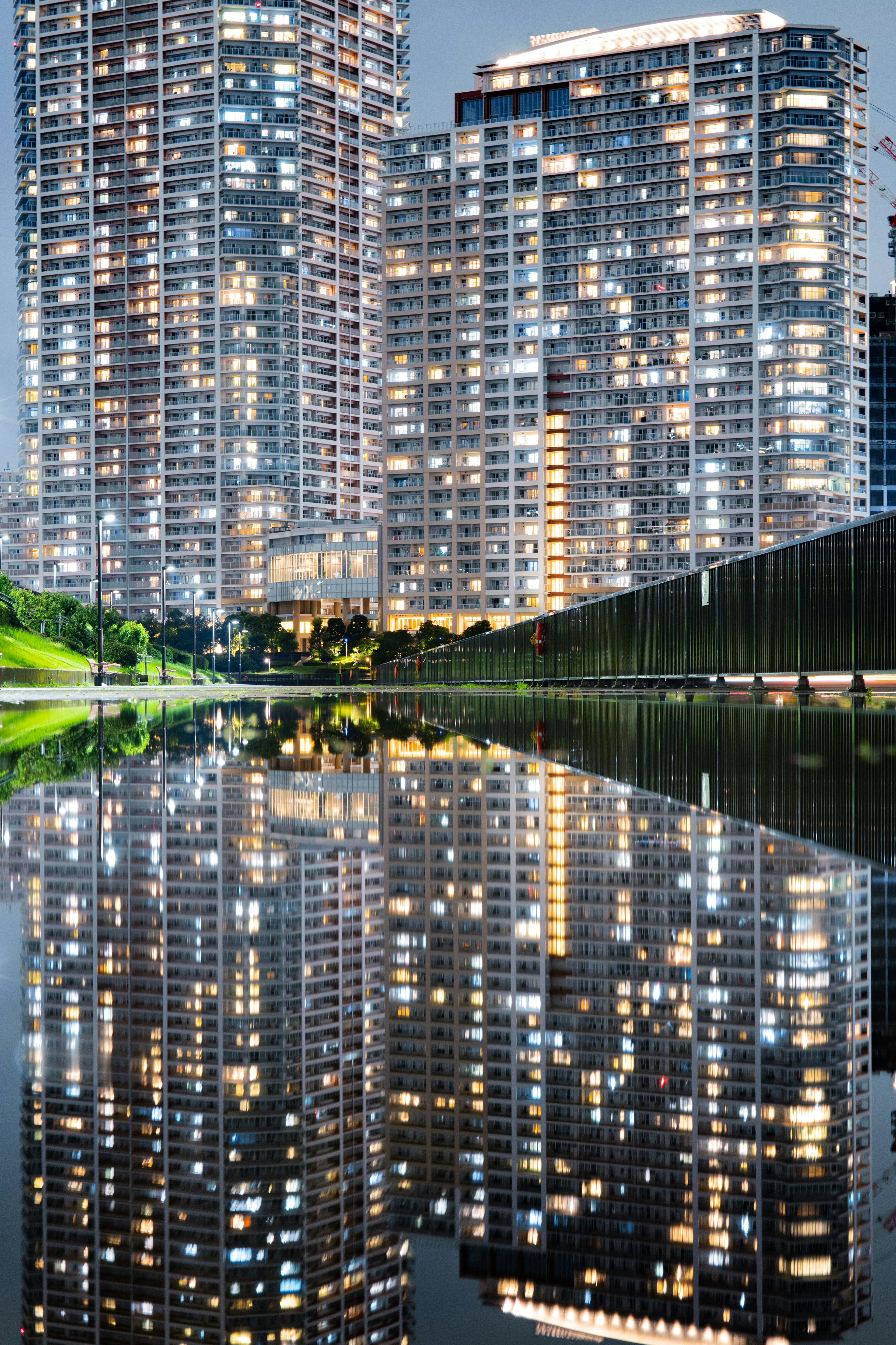 高層ビルが水面に反射している夜景の都市風景