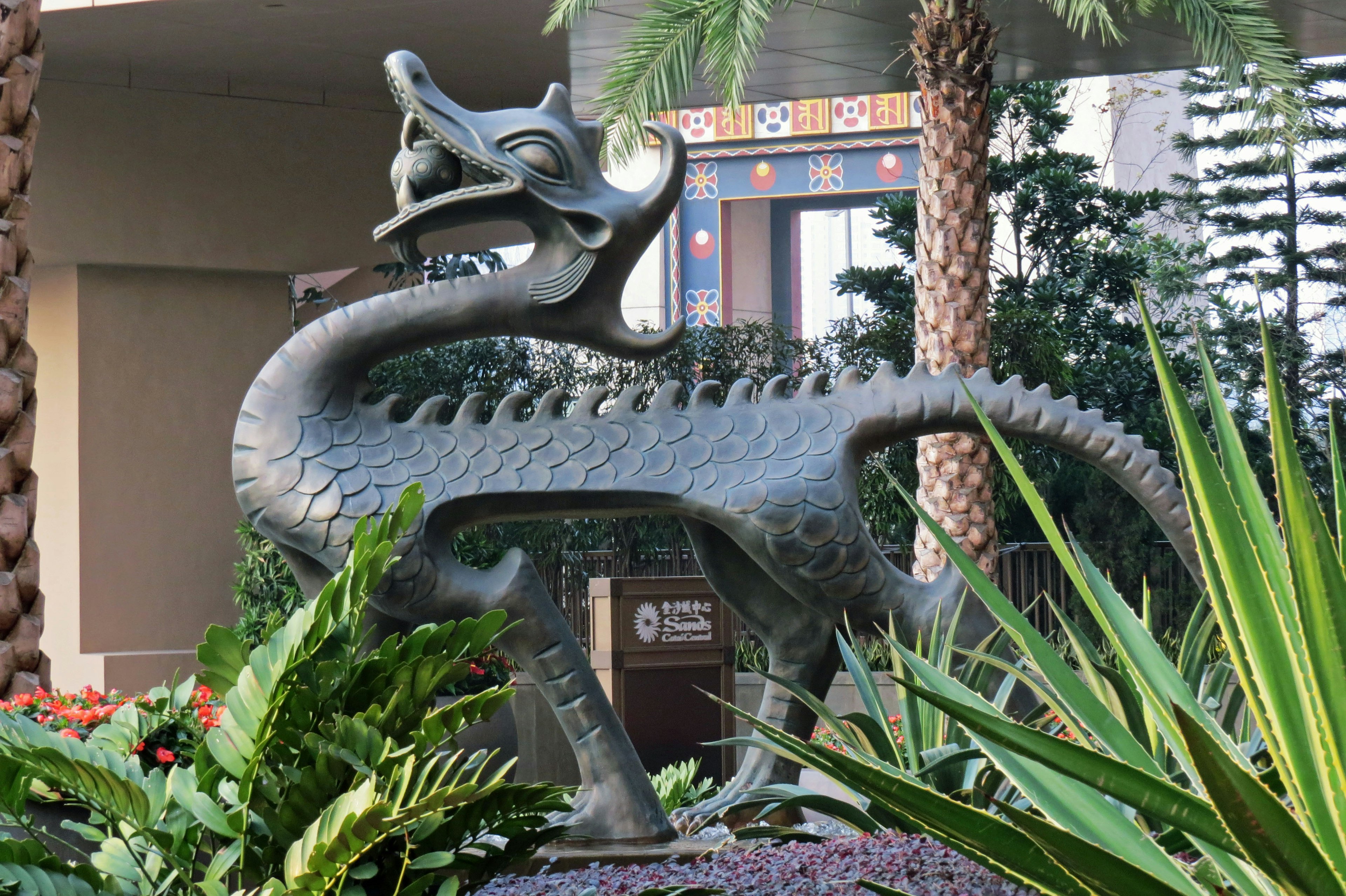 Une statue de dragon sculptée entourée de plantes vertes