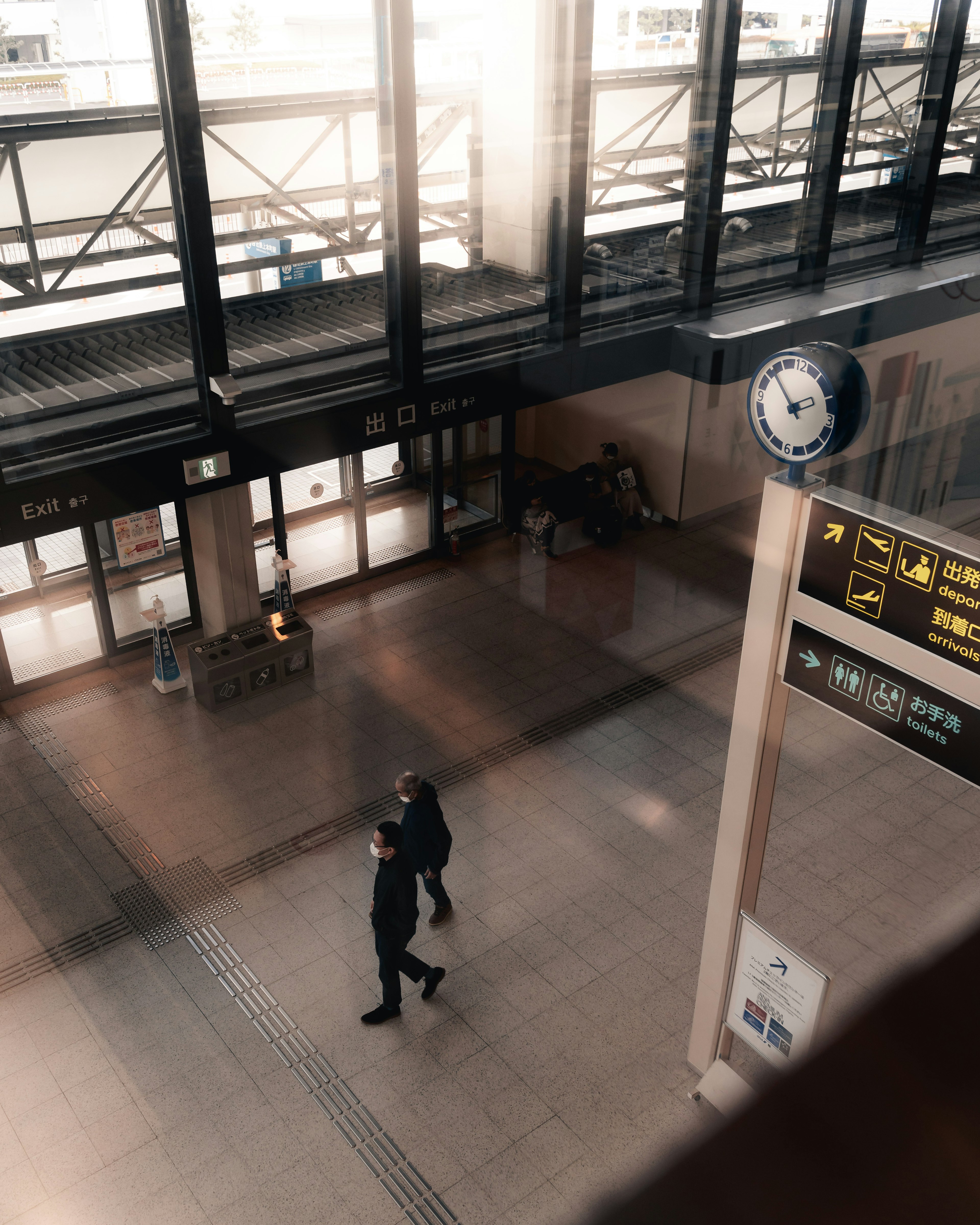 Vista interior de una estación de tren personas caminando iluminación brillante y diseño moderno