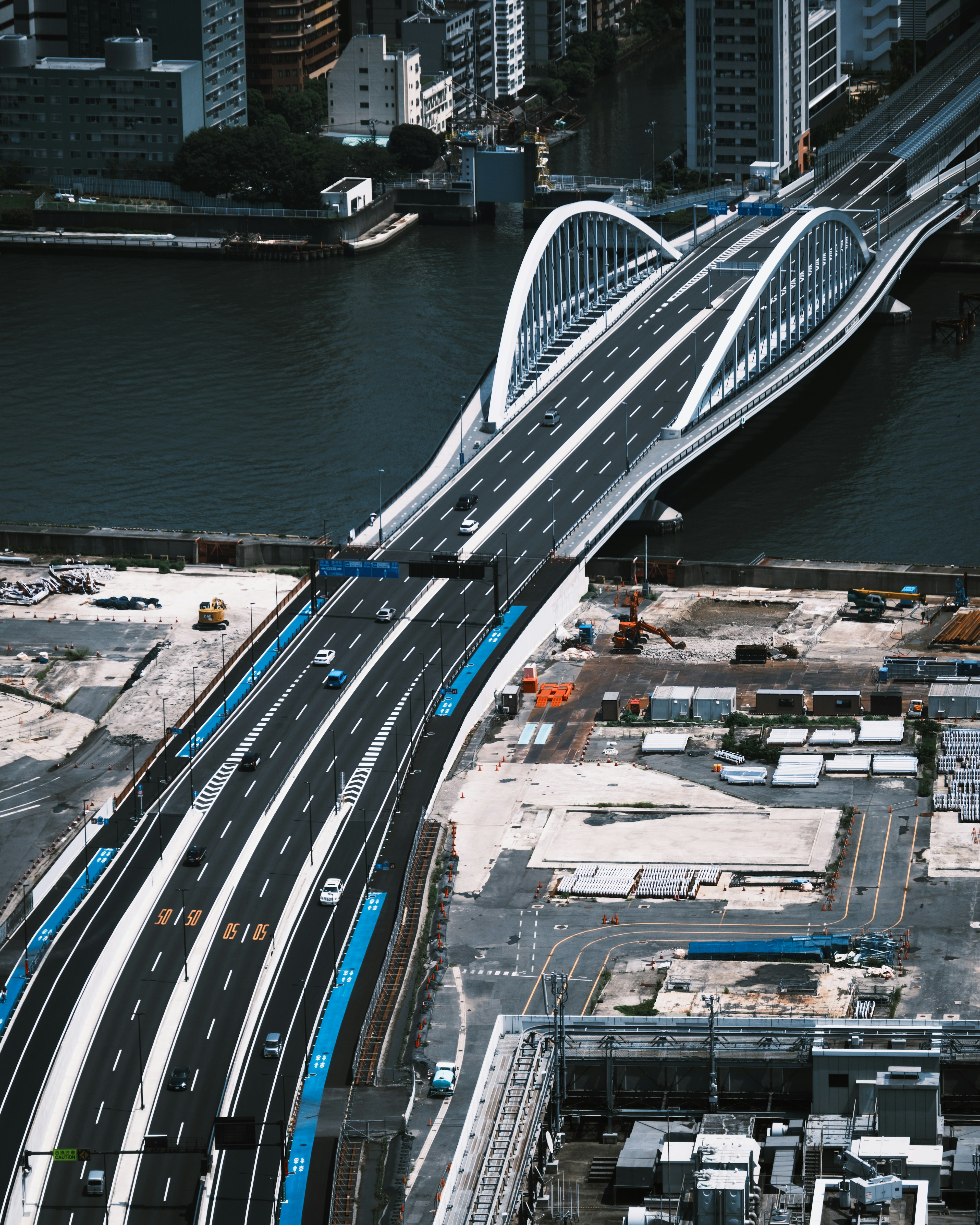 Futuristic bridge design over a river with urban surroundings