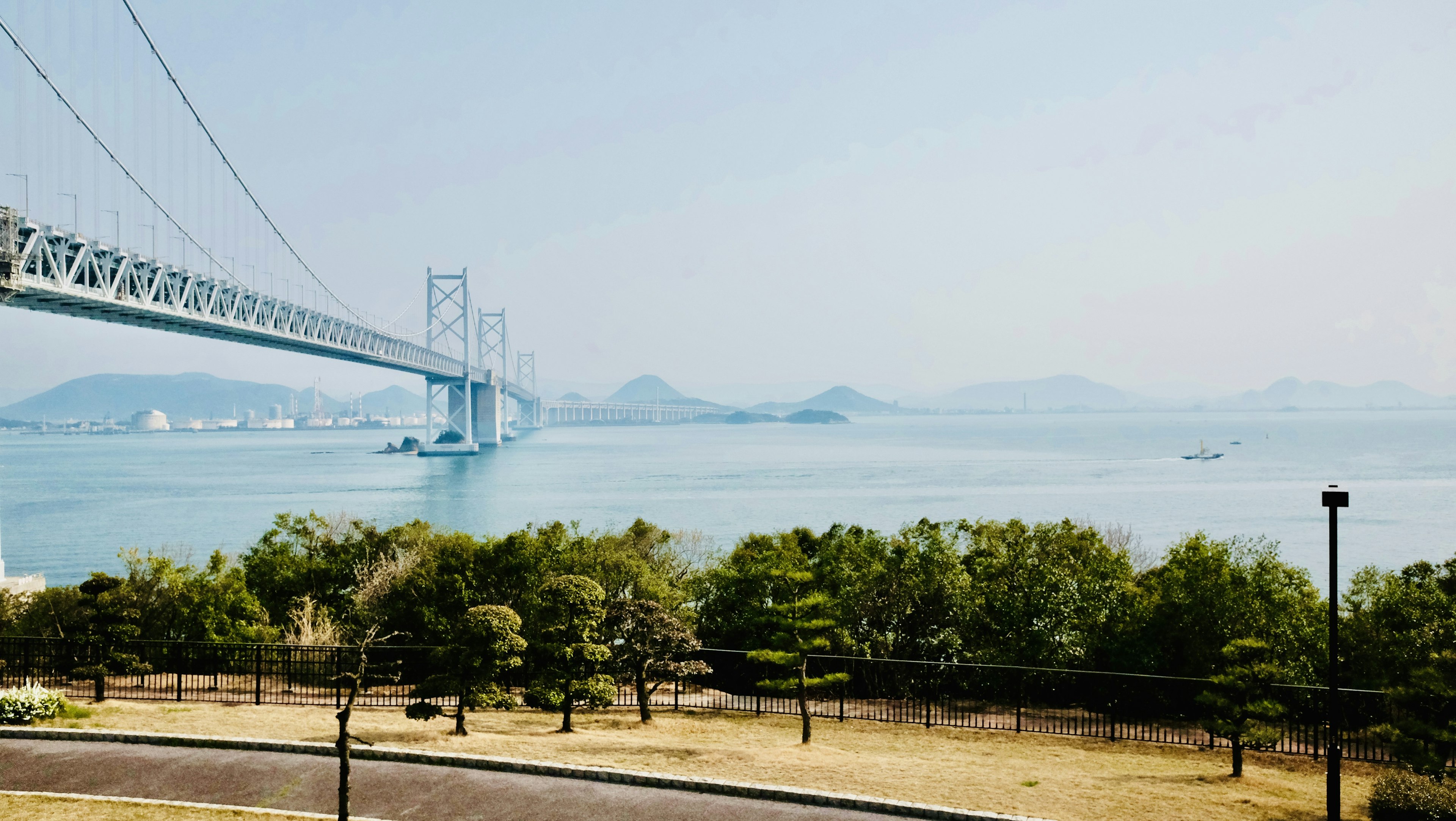 Large bridge spanning a calm sea under a light blue sky