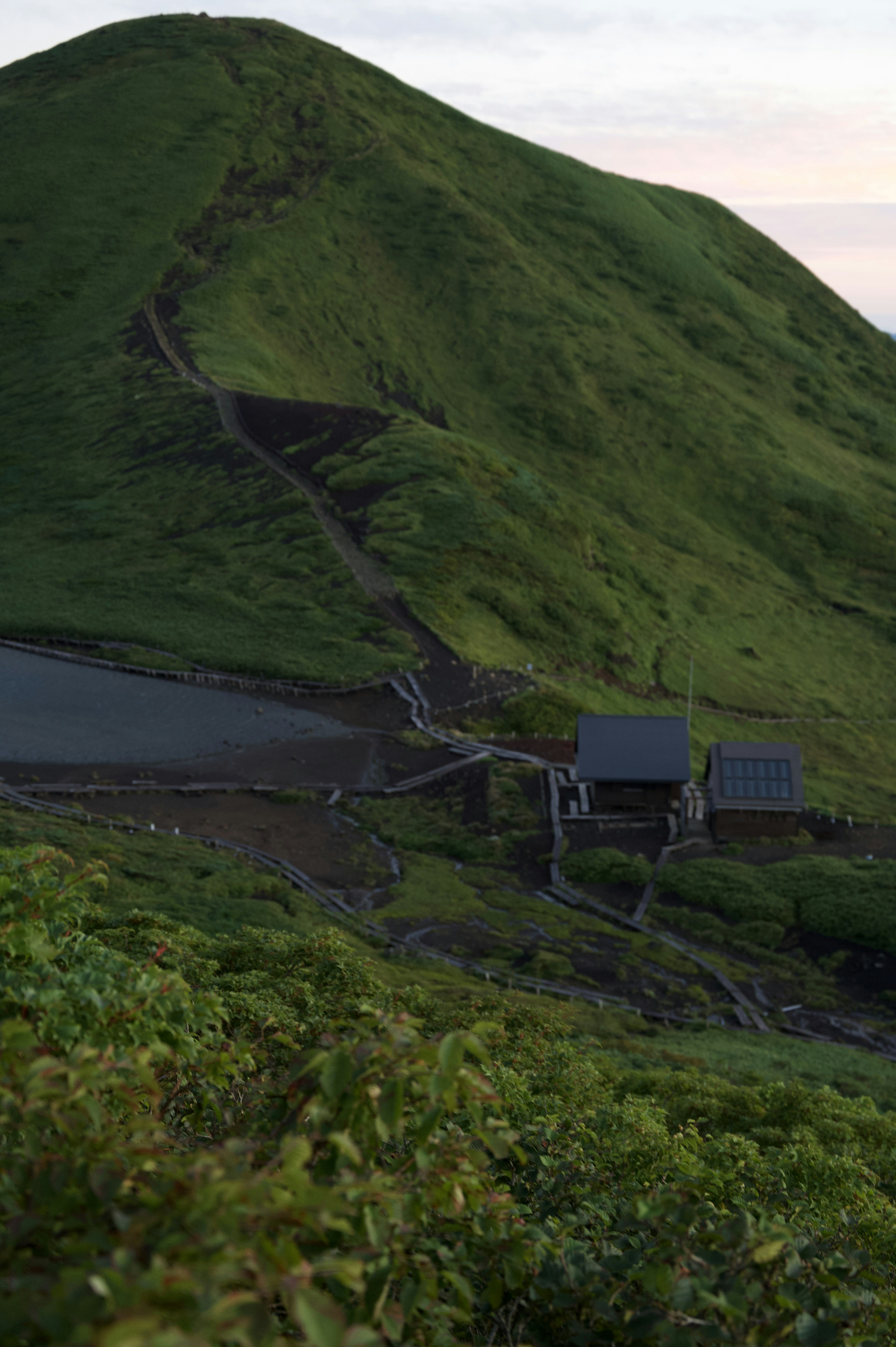 緑の山と小屋の風景、道が続いている