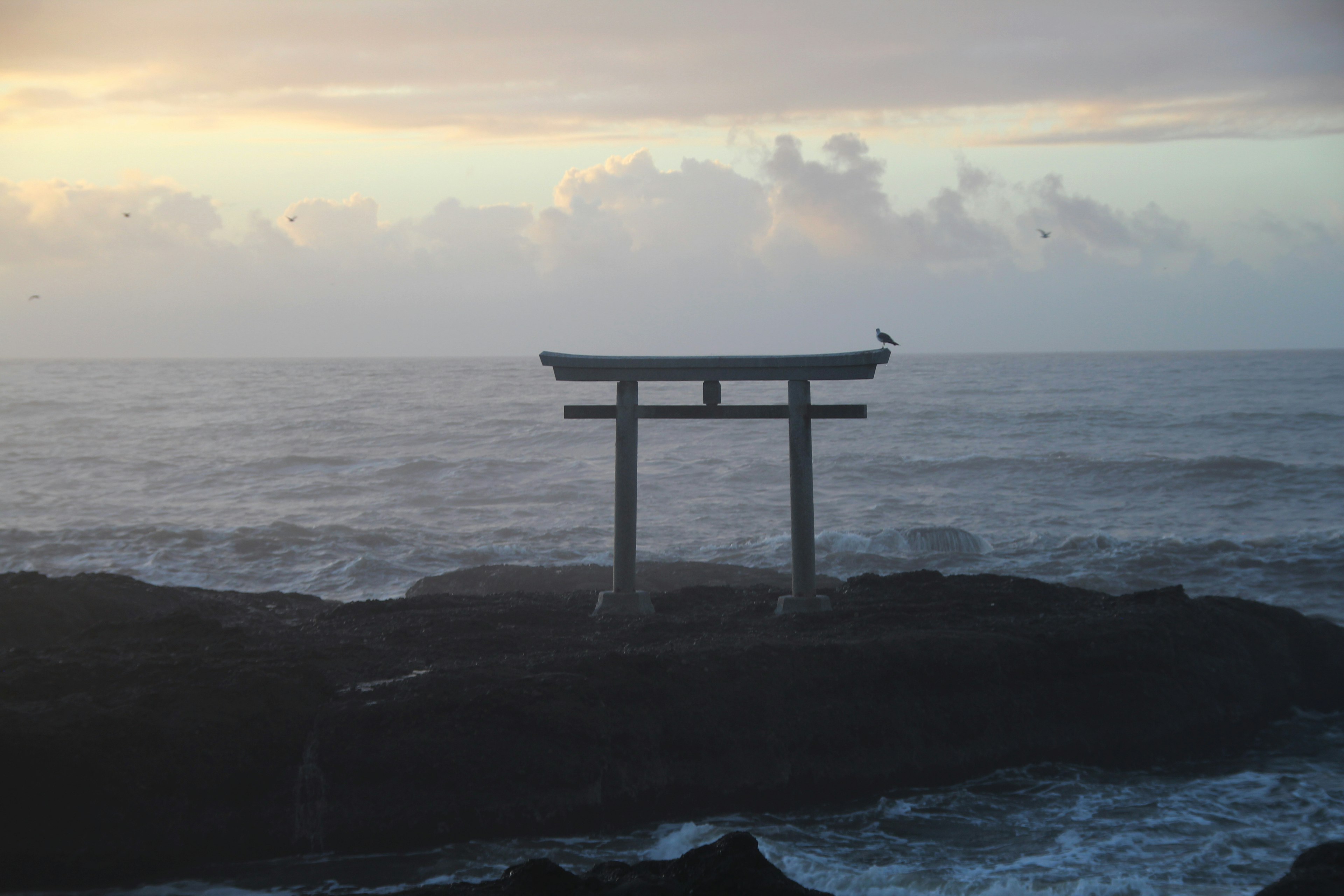 Torii en el mar con un fondo de atardecer