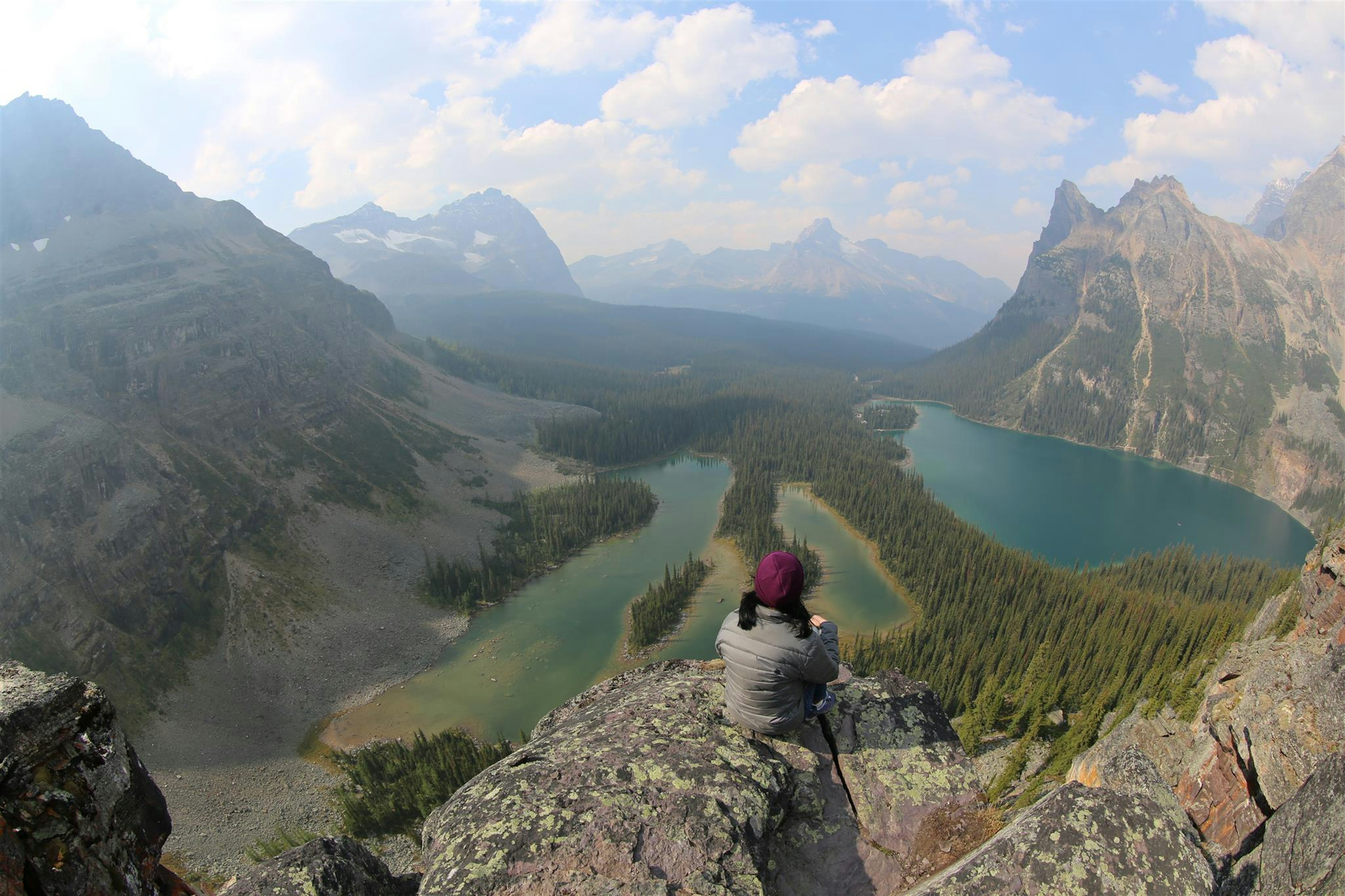 Randonneur appréciant une vue panoramique sur des montagnes et des lacs majestueux