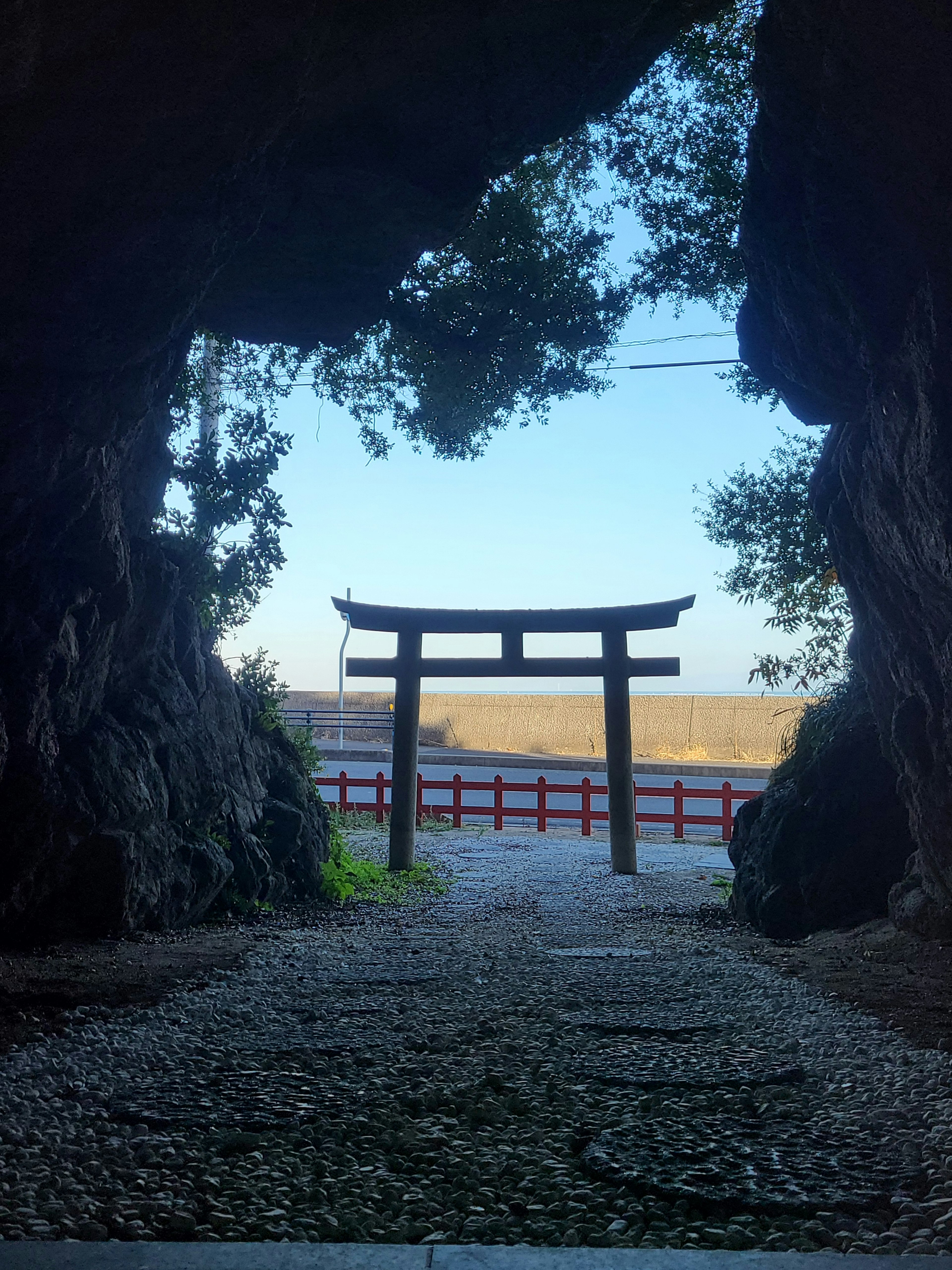 Vue d'un torii à travers l'ouverture d'une grotte