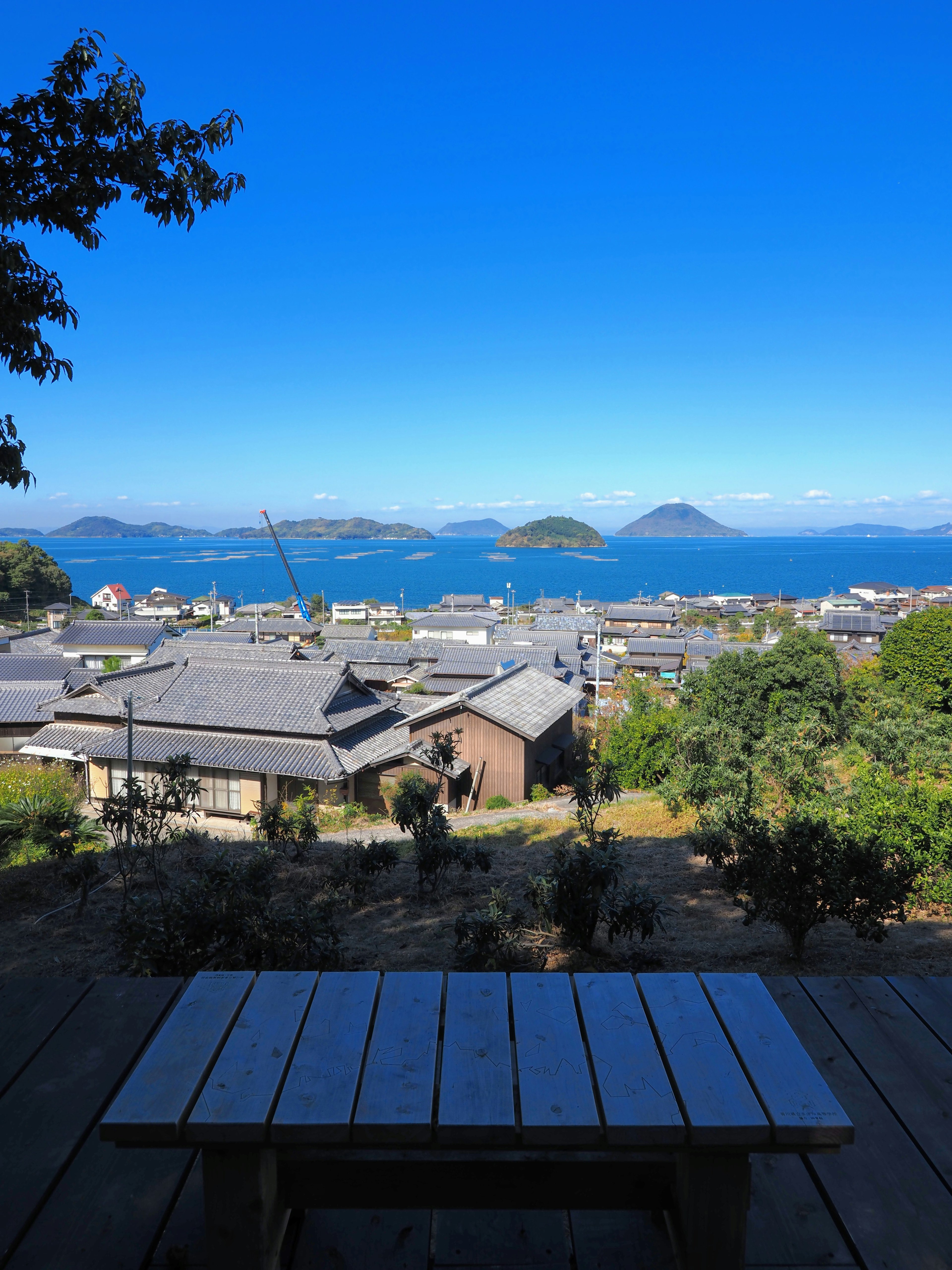 Vista panoramica del mare e delle isole con un tavolo di legno in primo piano