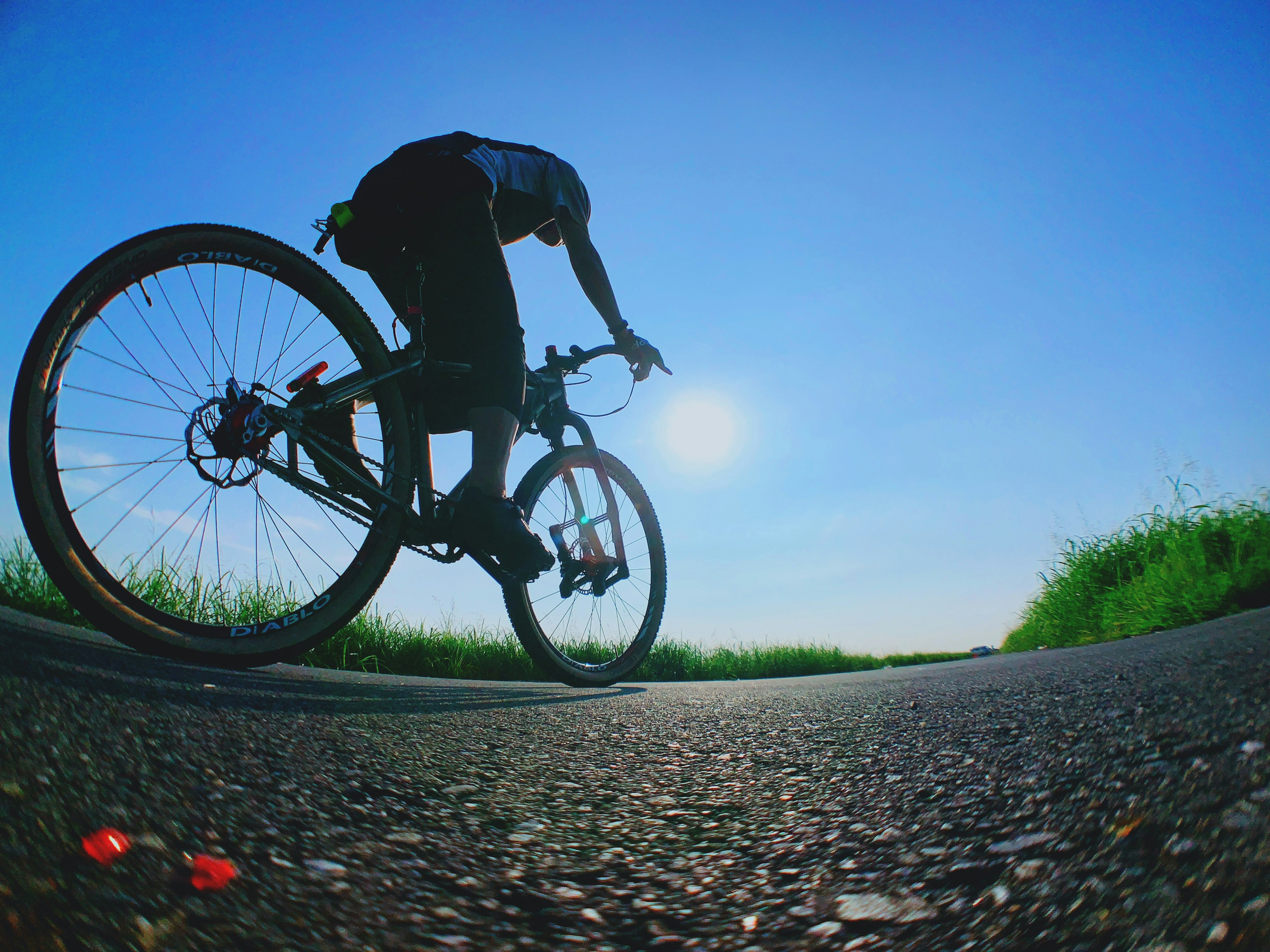 Personne faisant du vélo sur une route sous un ciel bleu