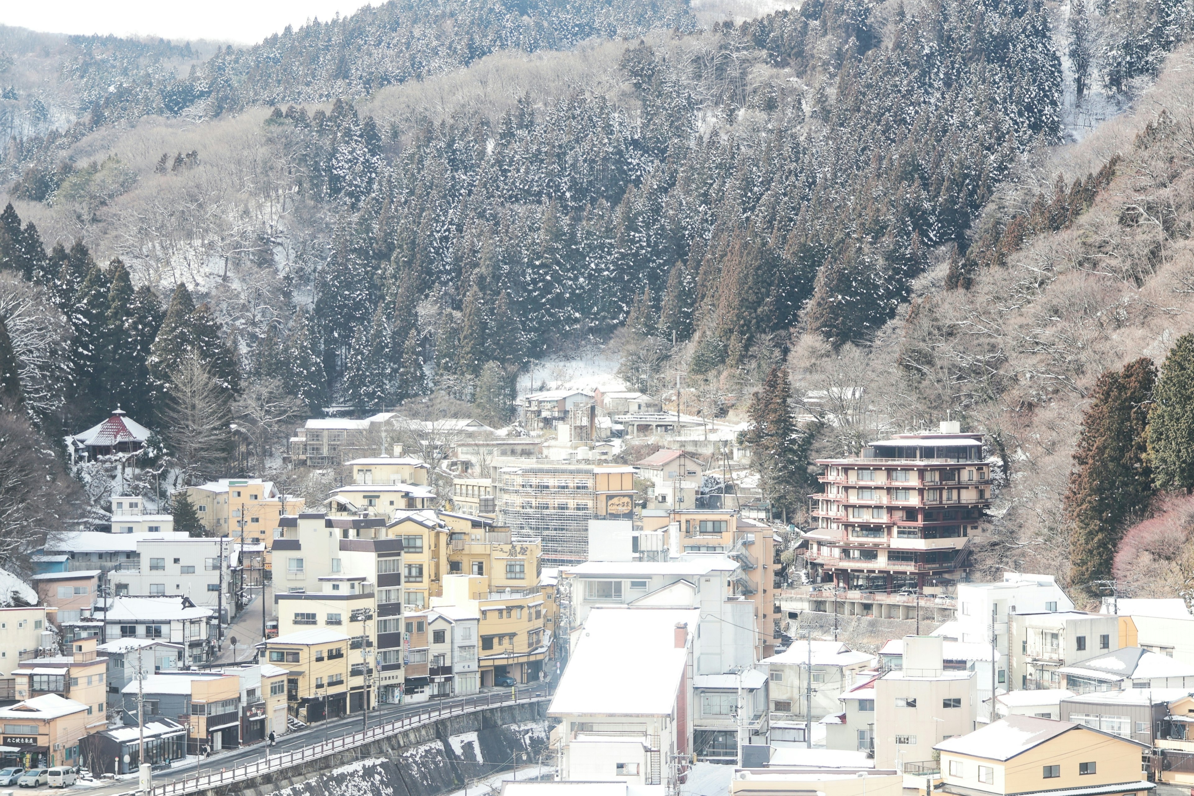 雪に覆われた温泉街の風景山々に囲まれた街並み