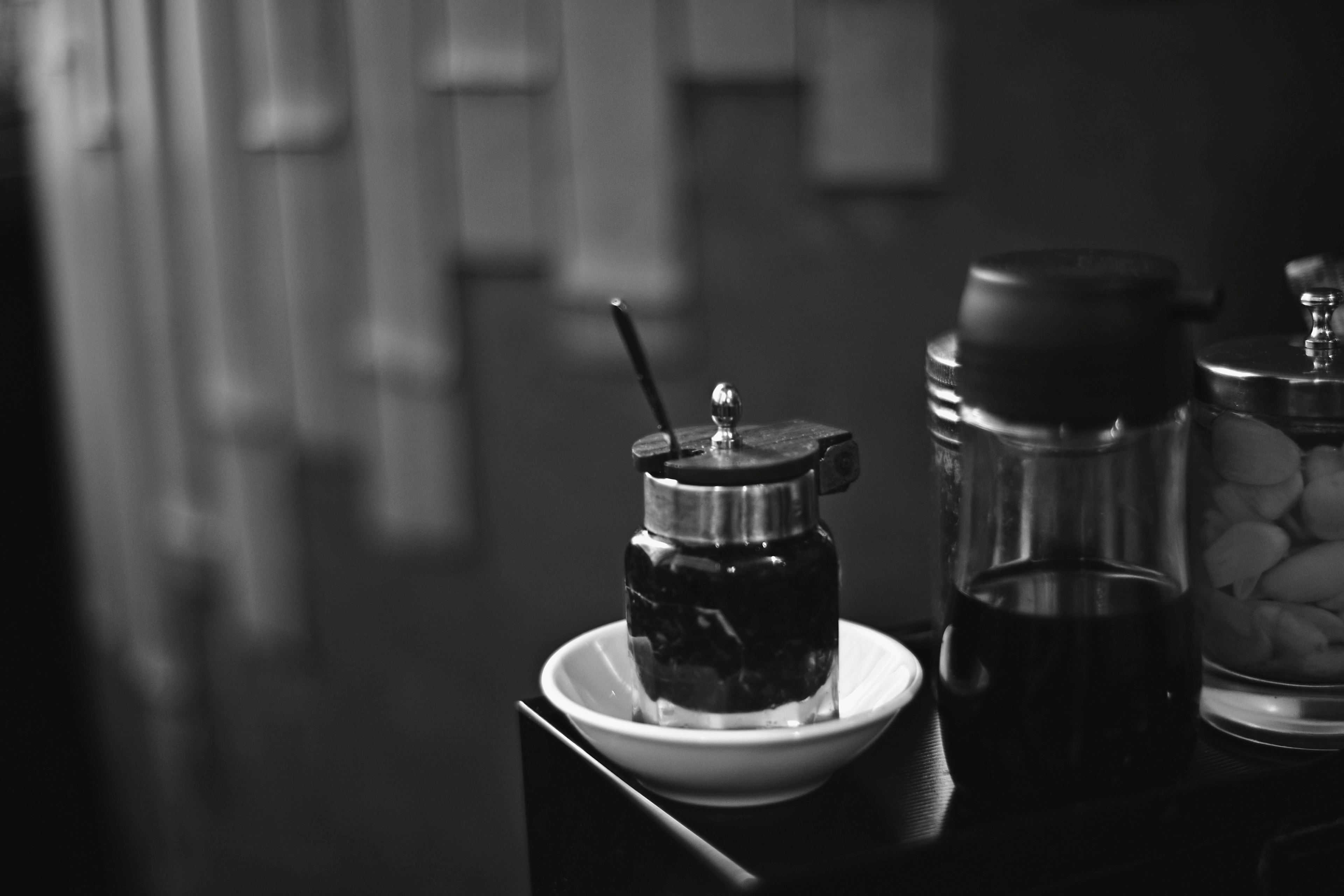 Presse française à café placée sur un plat blanc avec une tasse en monochrome