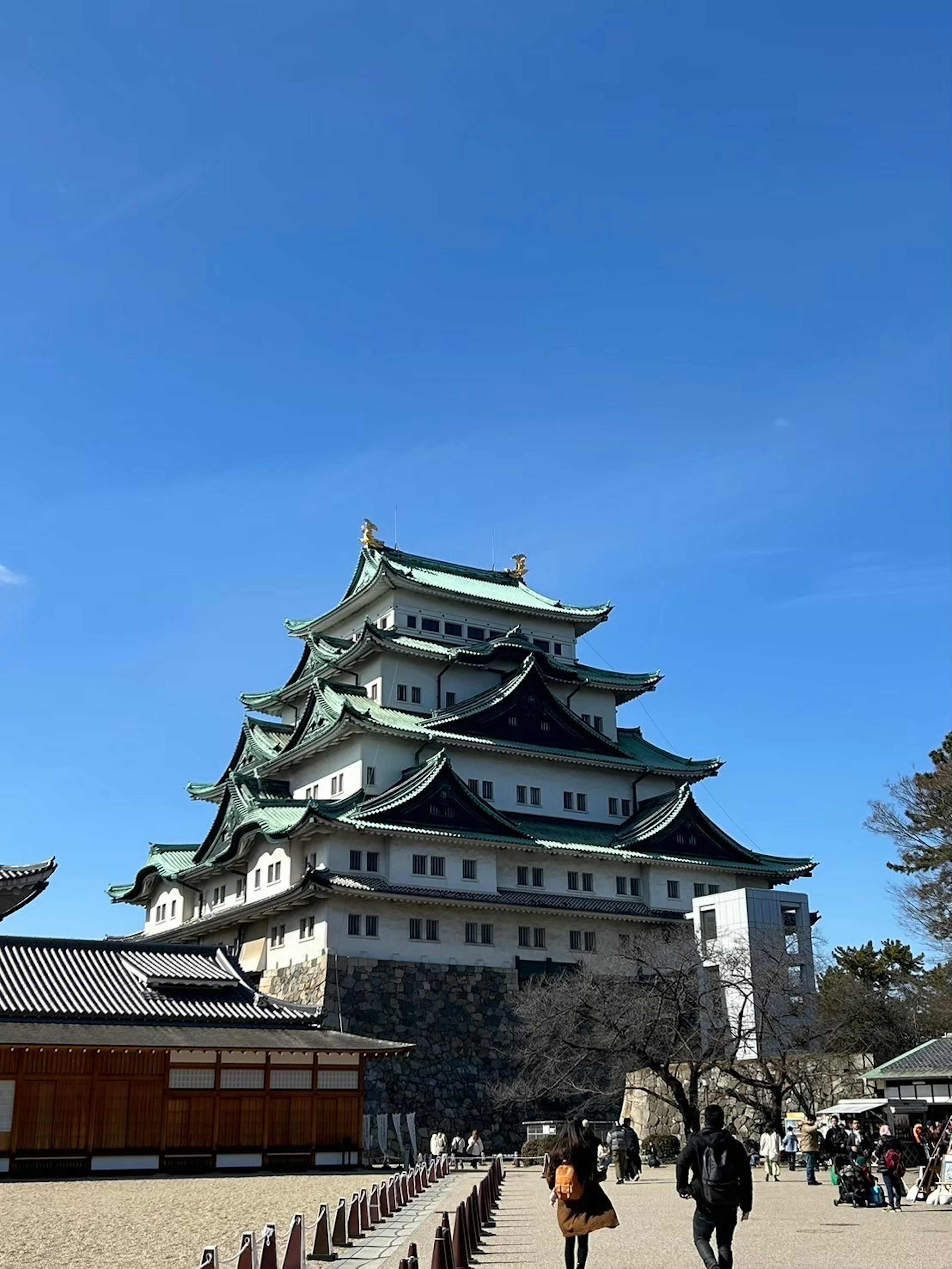 L'extérieur magnifique du château de Nagoya avec des touristes sous un ciel bleu