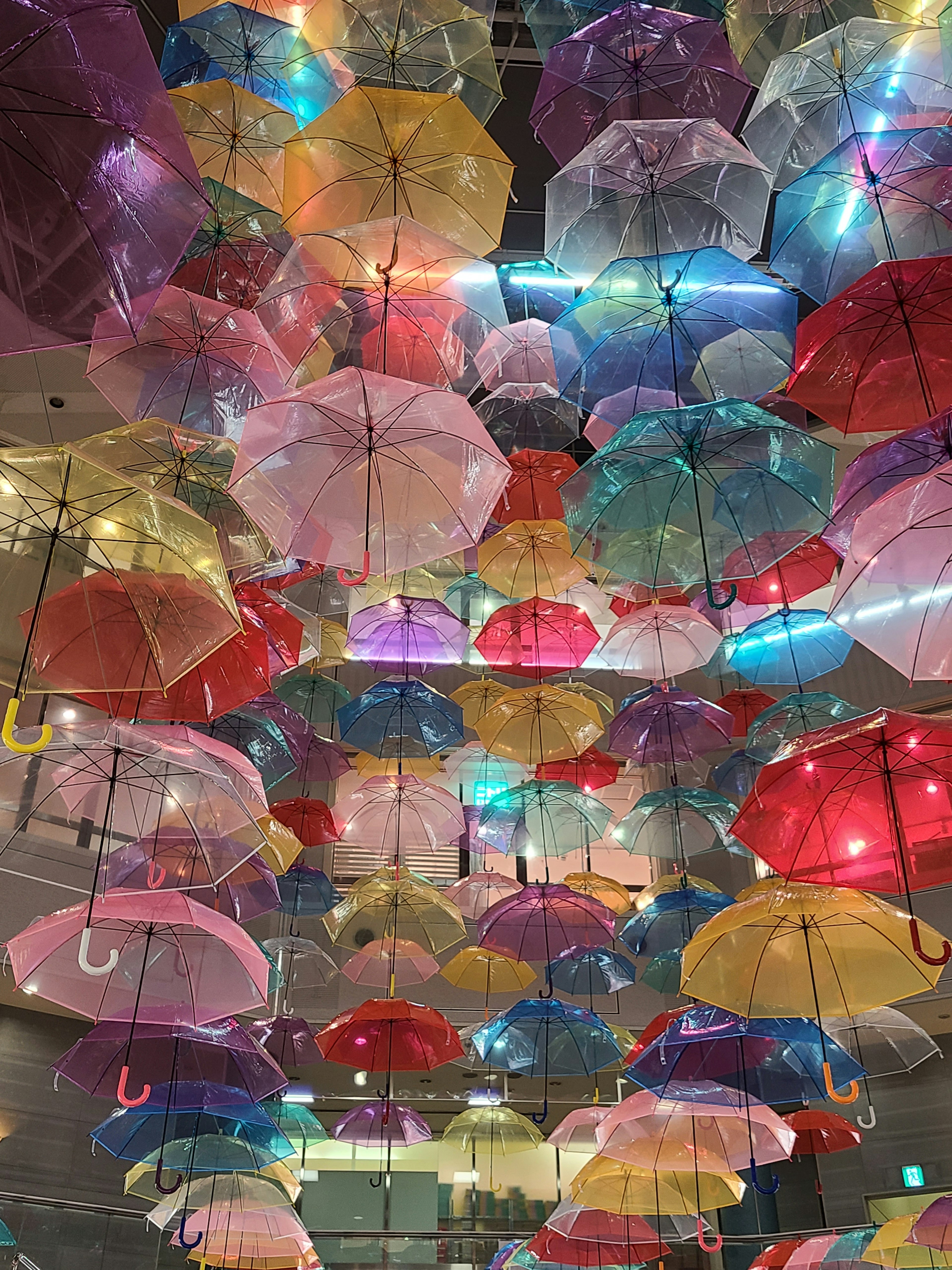 Des parapluies colorés suspendus au plafond dans une installation artistique