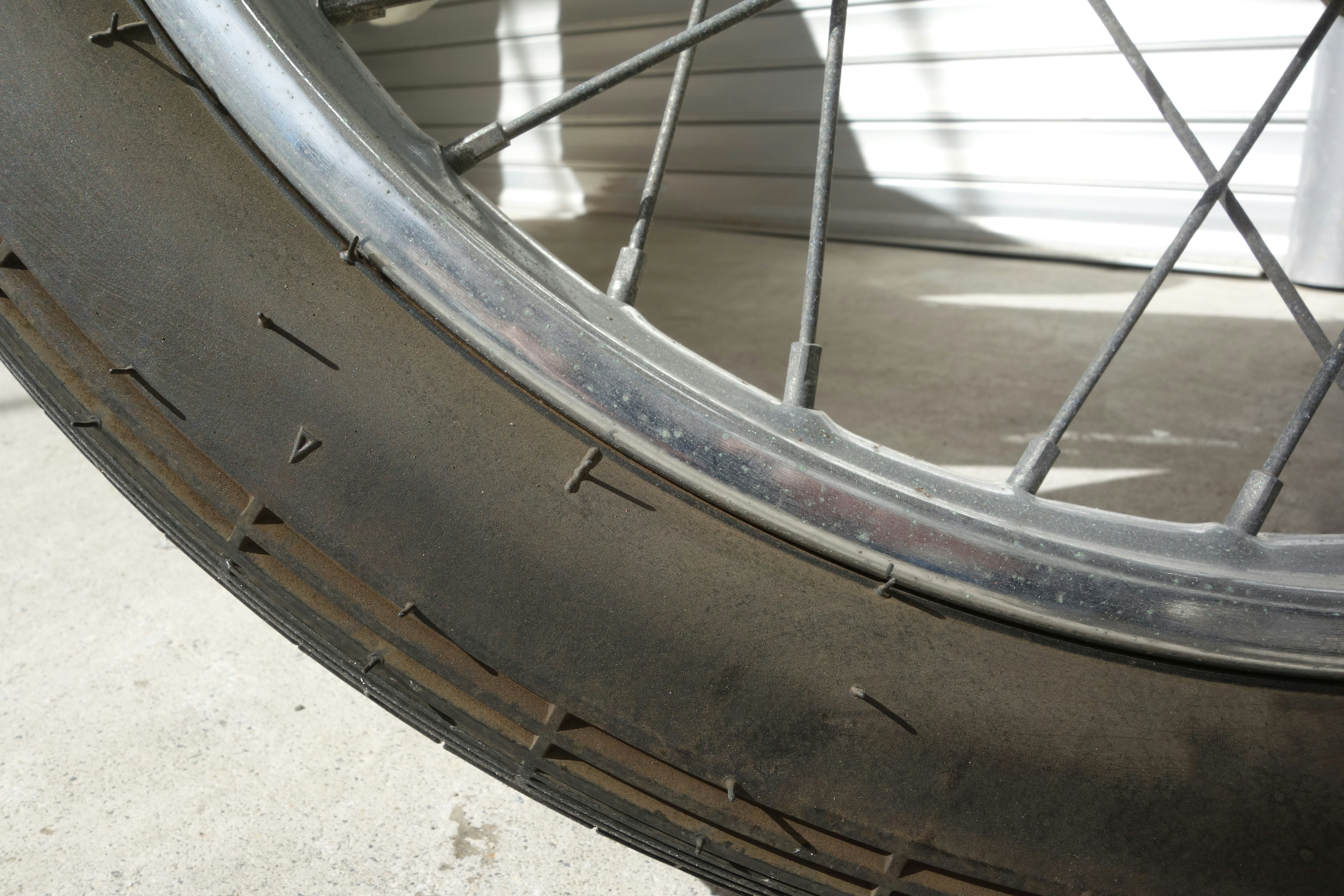 Close-up photo of a bicycle tire showing the silver rim and black tire