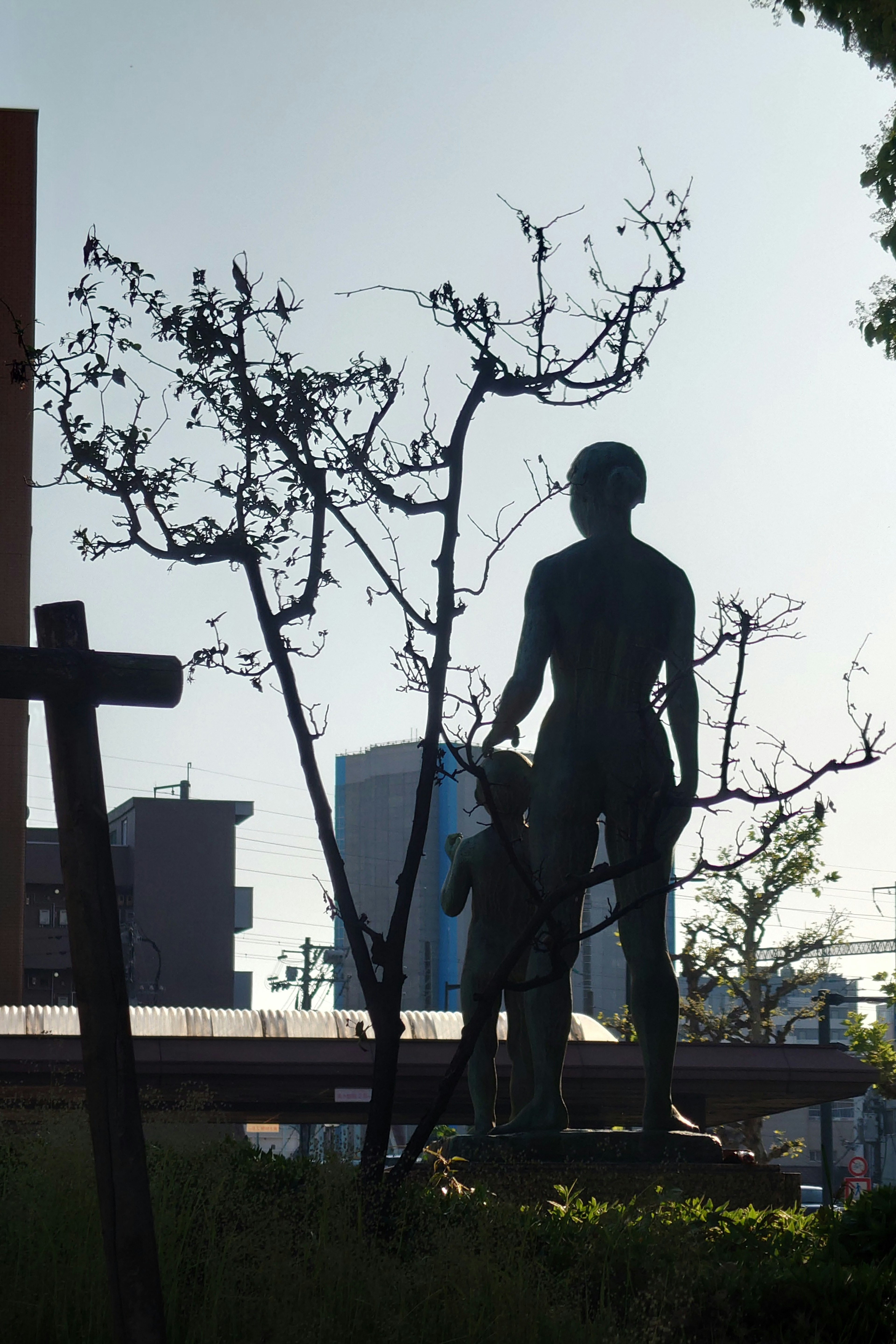 Silhouette of a statue with a child in a park setting