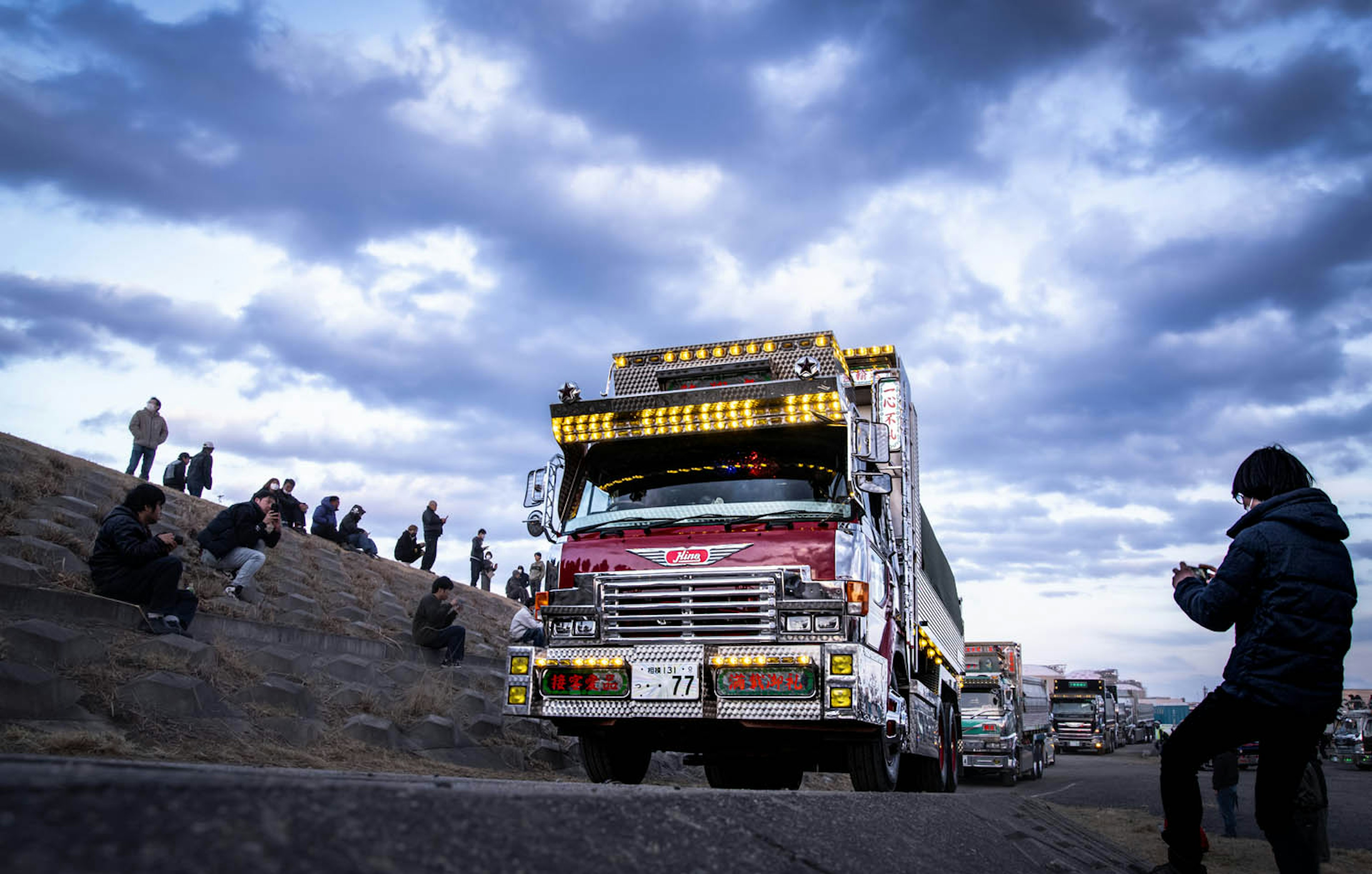 Camion colorato su una strada con spettatori nelle vicinanze