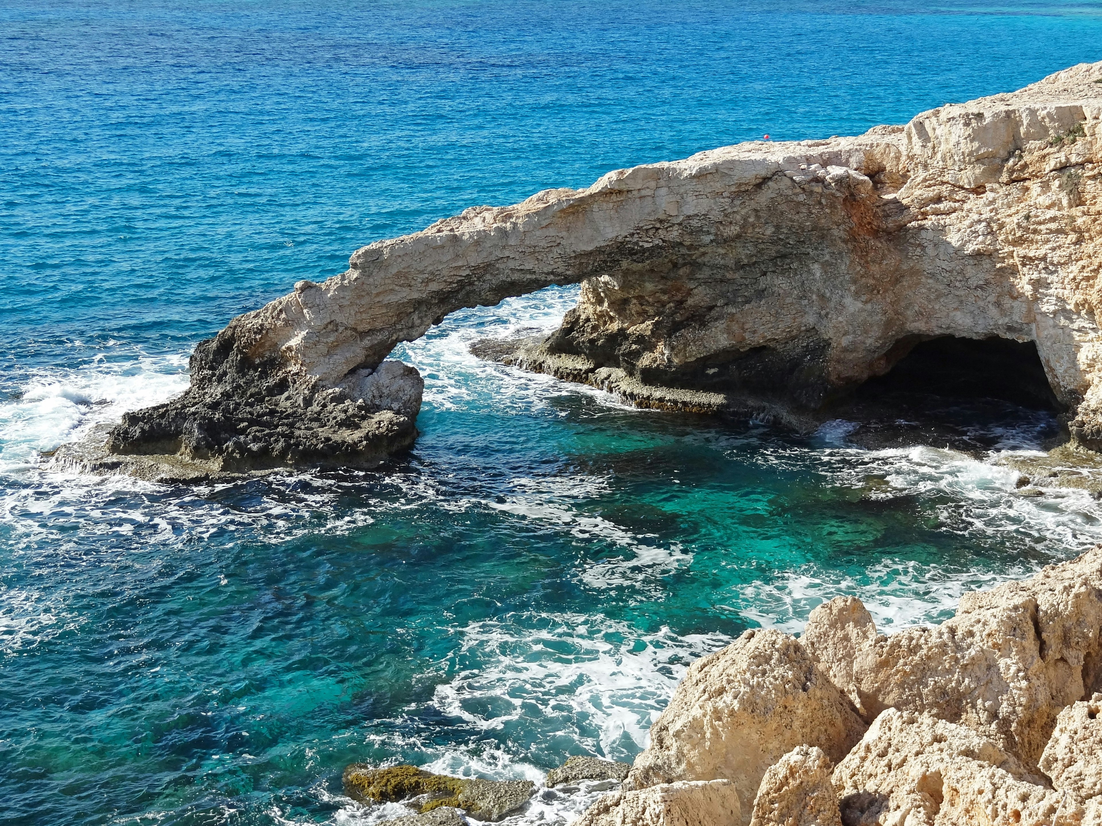 Scenic view featuring a rock arch over turquoise waters