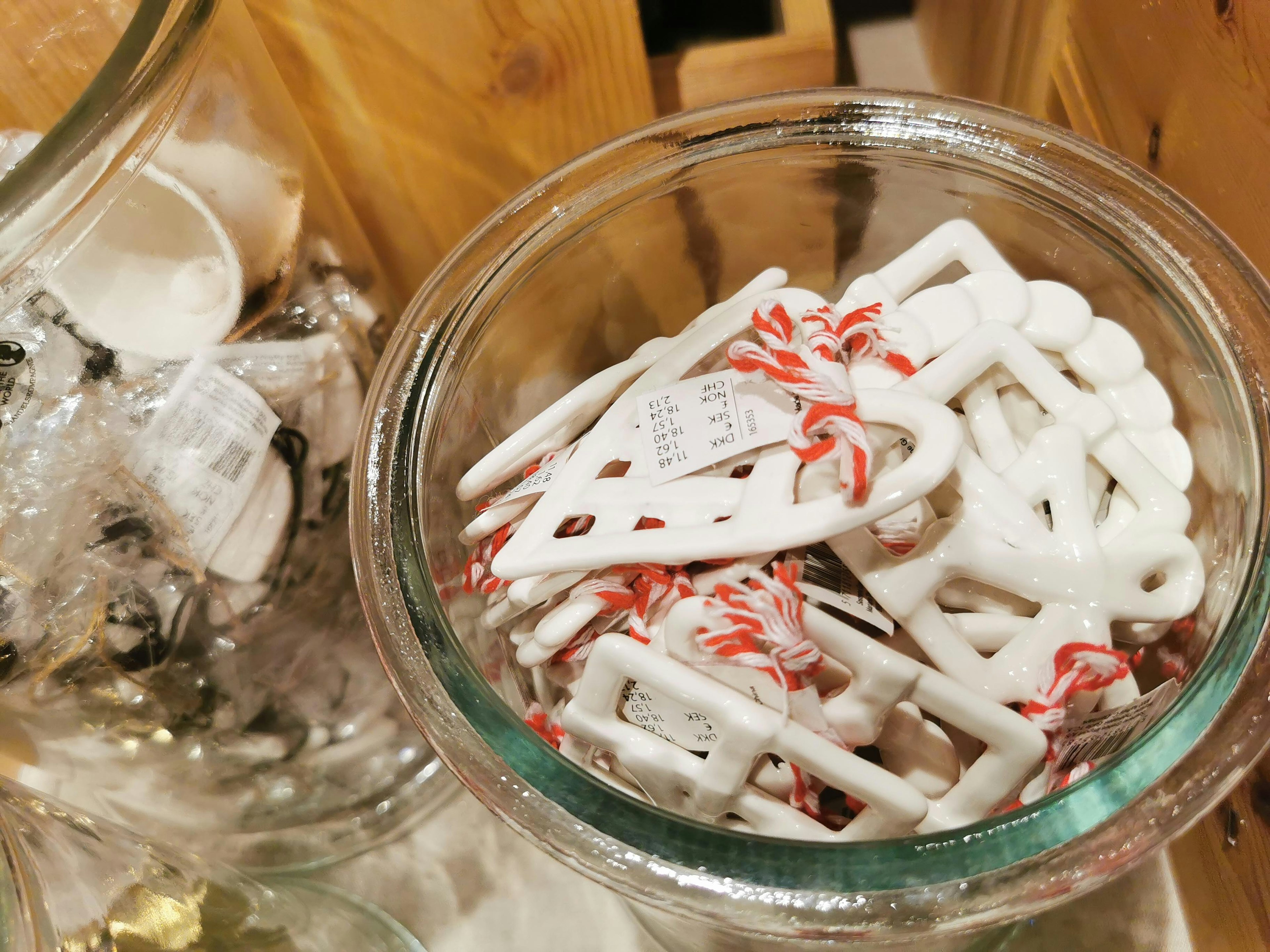 Glass container filled with white skate-shaped ornaments and red candy