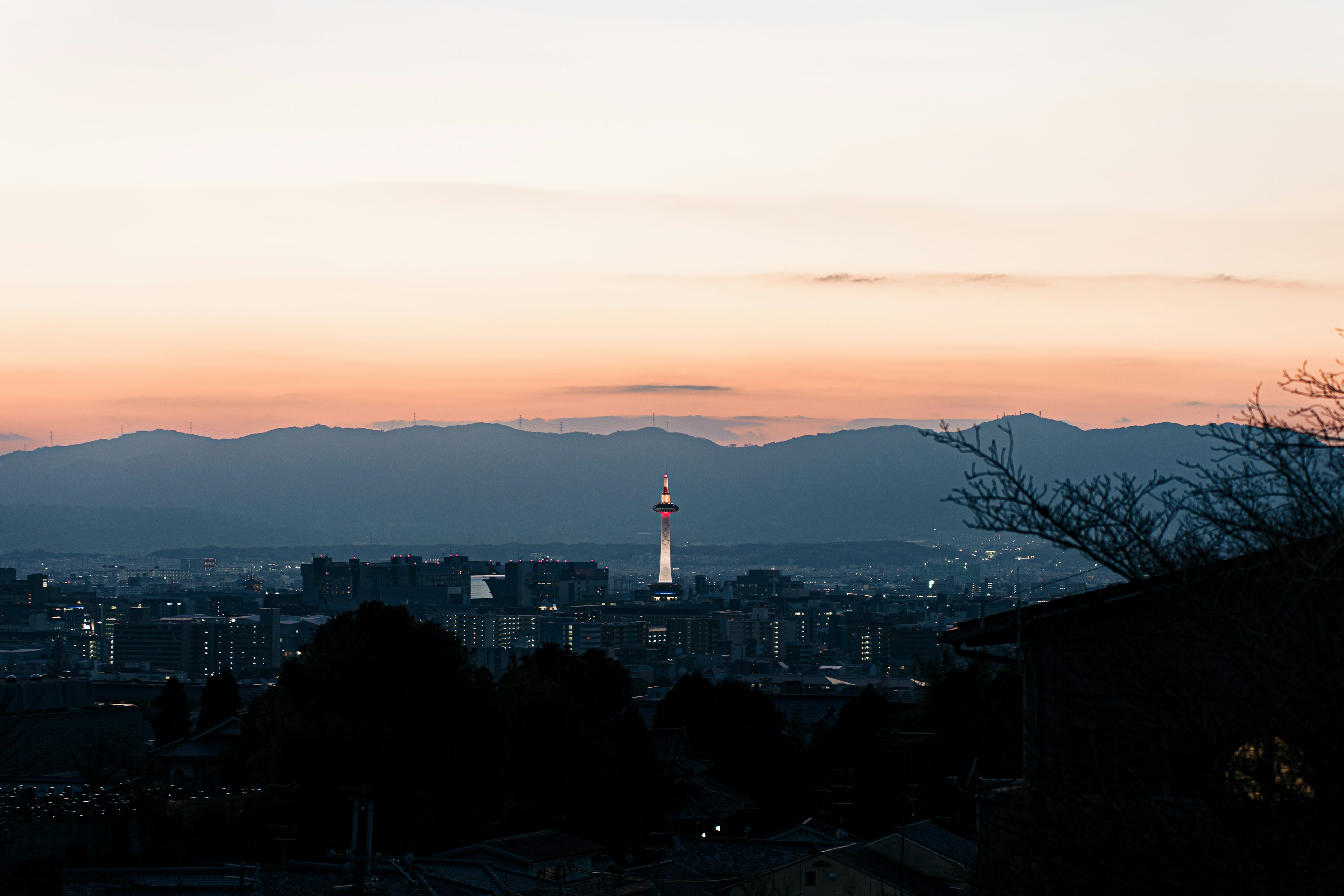 Stadtansicht mit einem Turm vor einem Sonnenuntergangshimmel