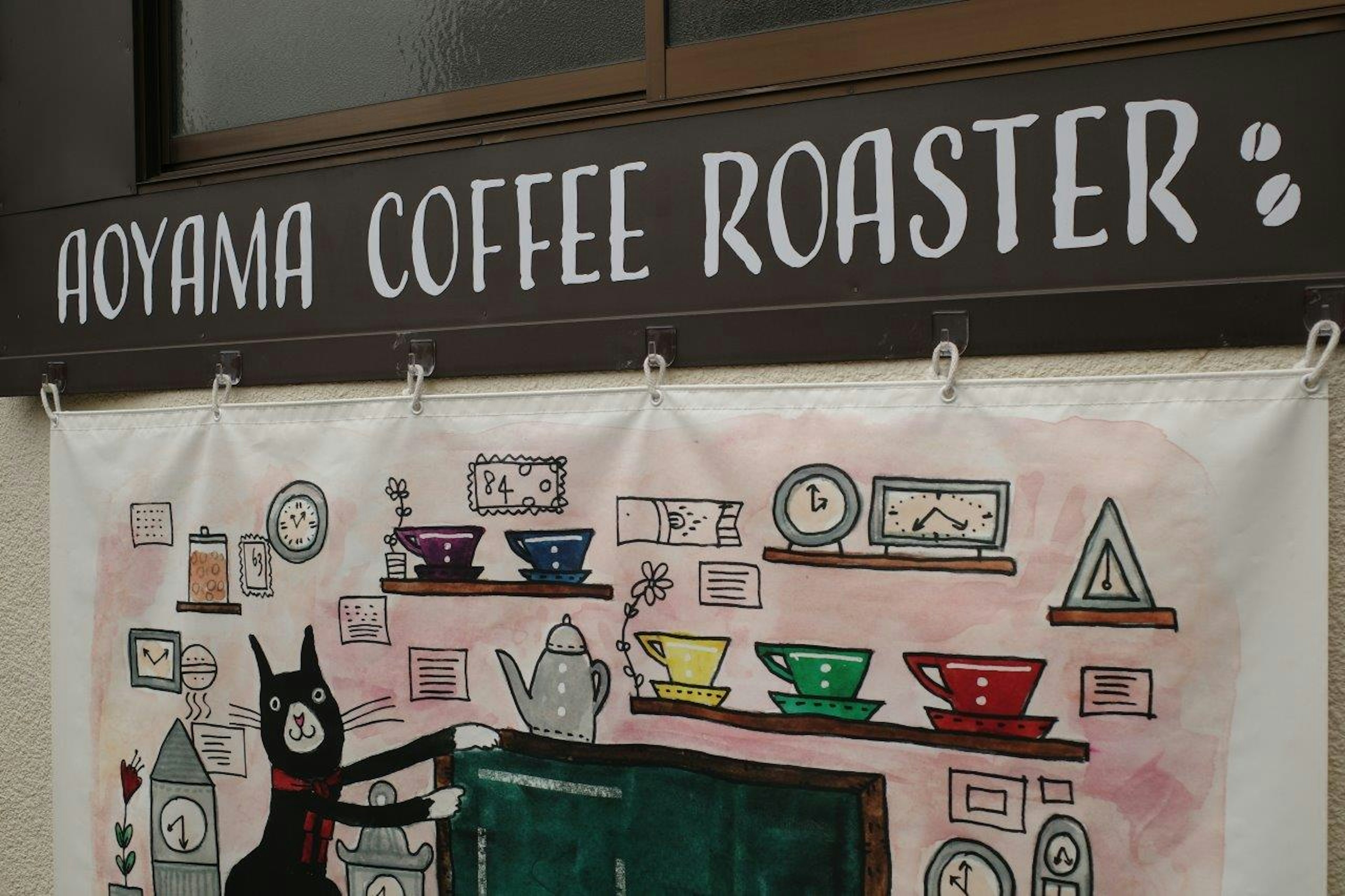 ป้าย Aoyama Coffee Roaster พร้อมภาพประกอบถ้วยกาแฟหลากสี