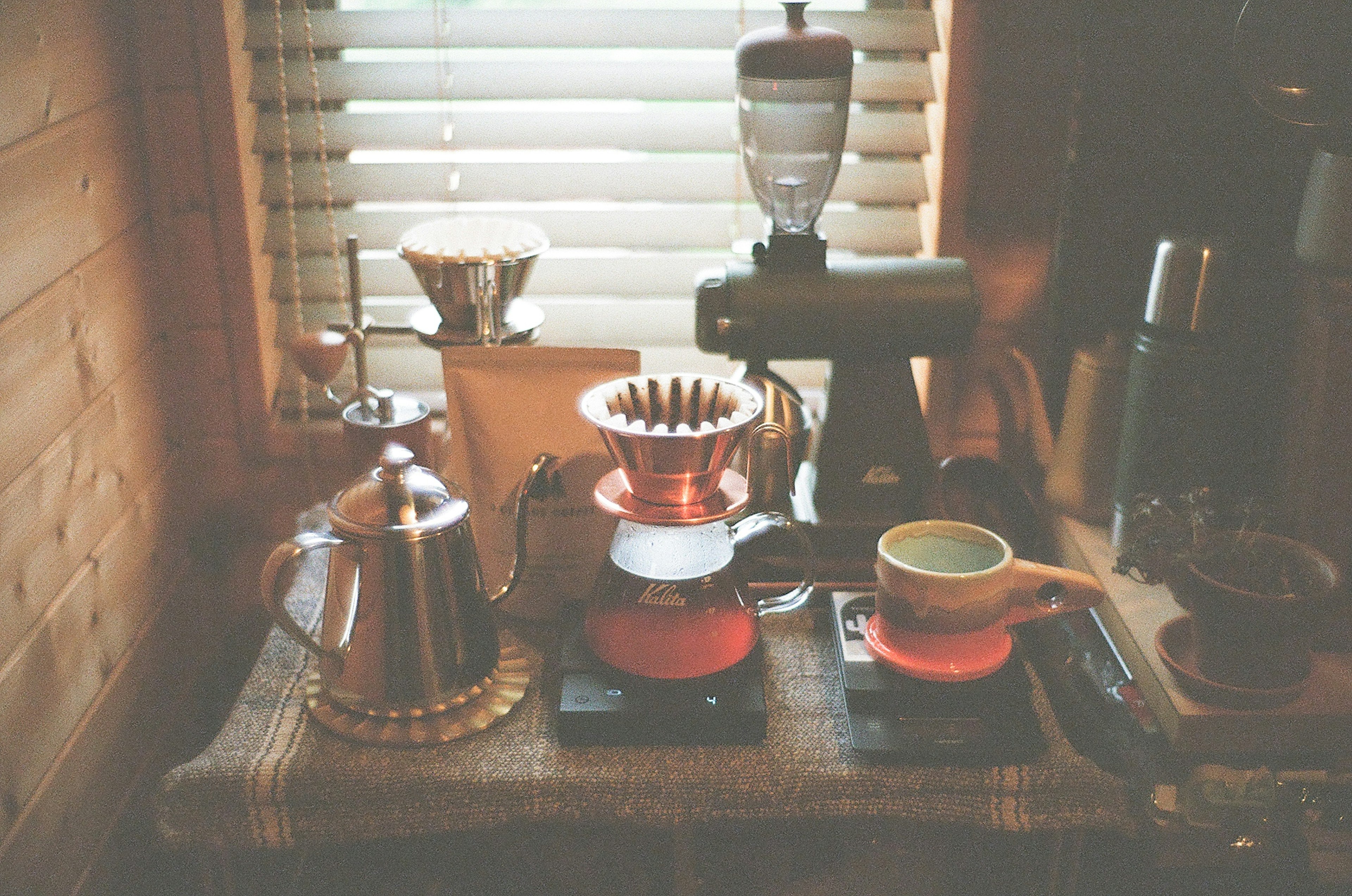 Coffee brewing setup with various tools on a wooden table