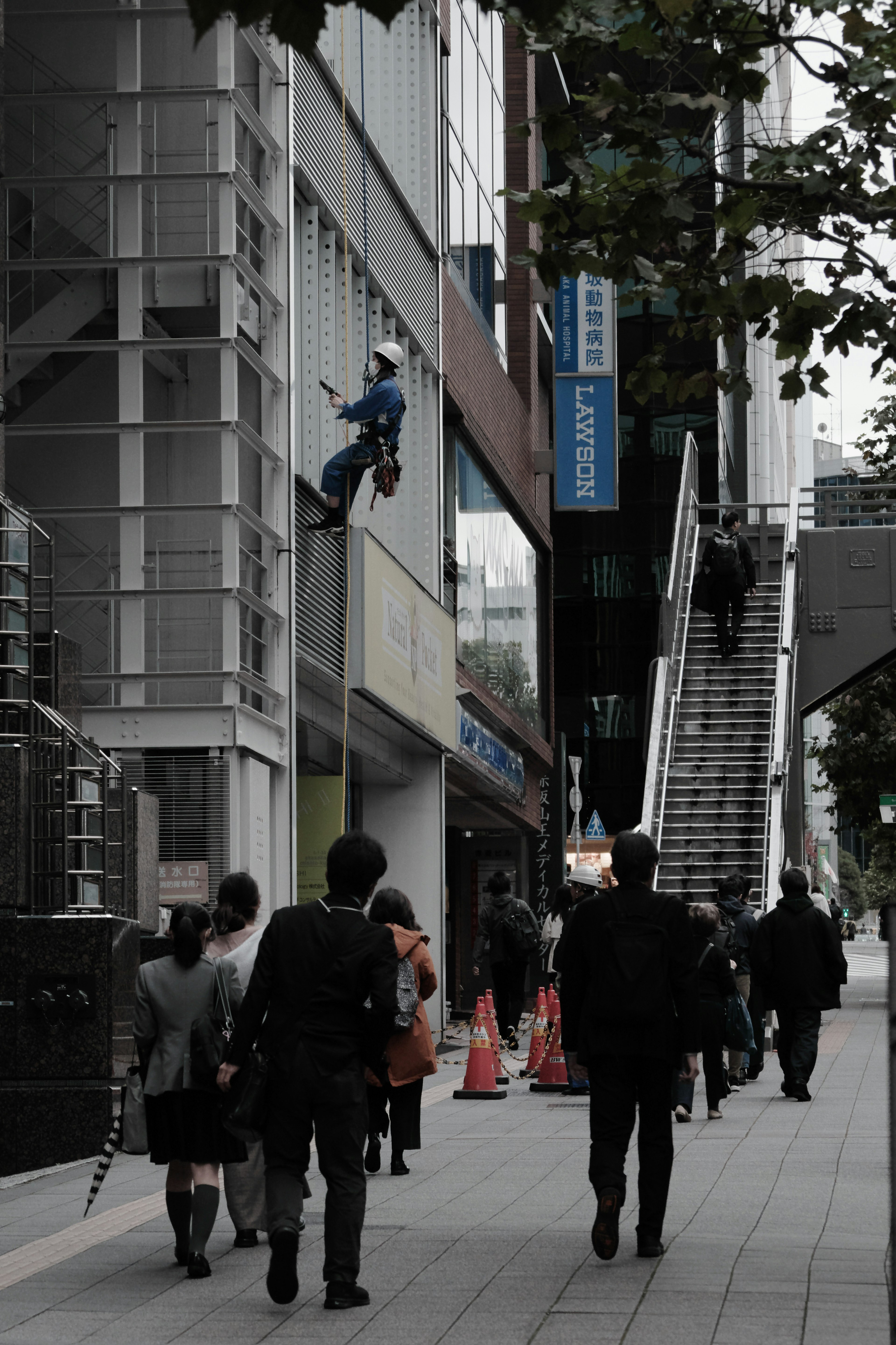 城市景观，工人在攀爬建筑物，行人走过