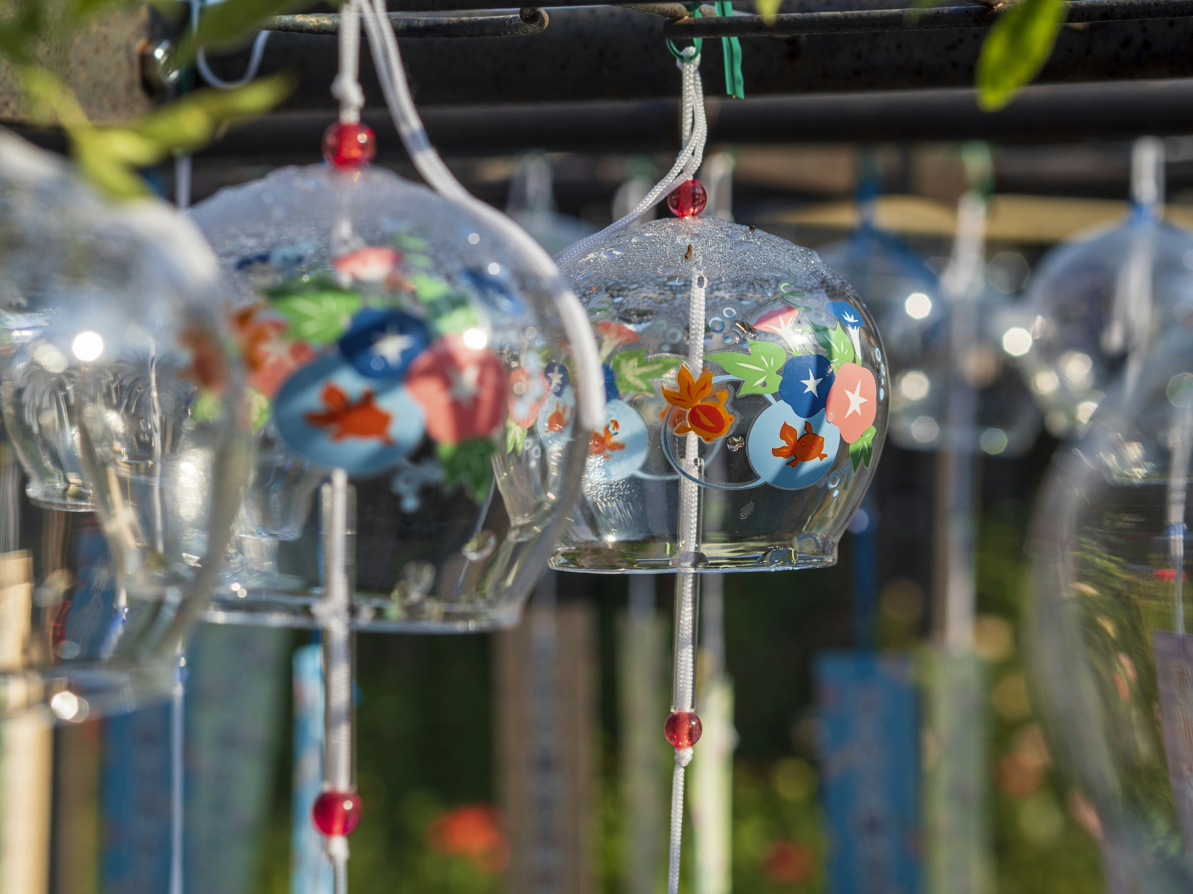 Carillons en verre à motifs floraux colorés suspendus en rangée