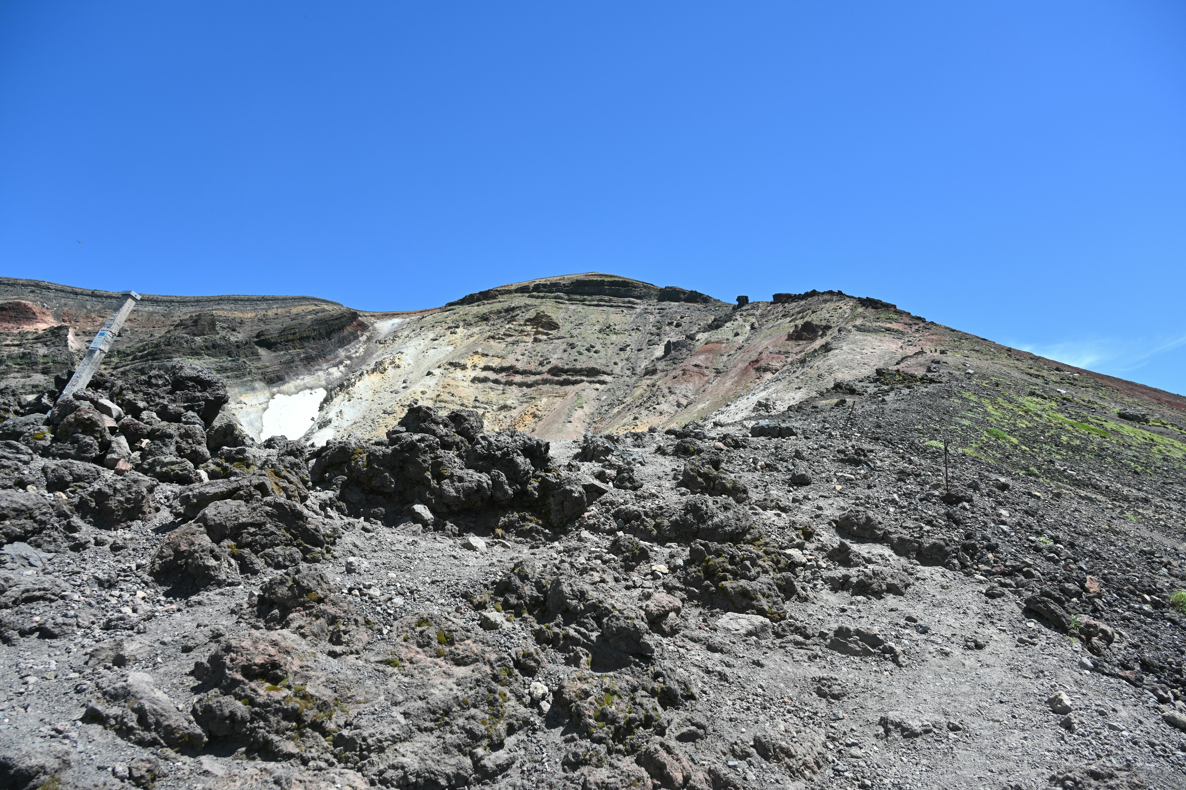 Paesaggio vulcanico accidentato sotto un cielo blu chiaro