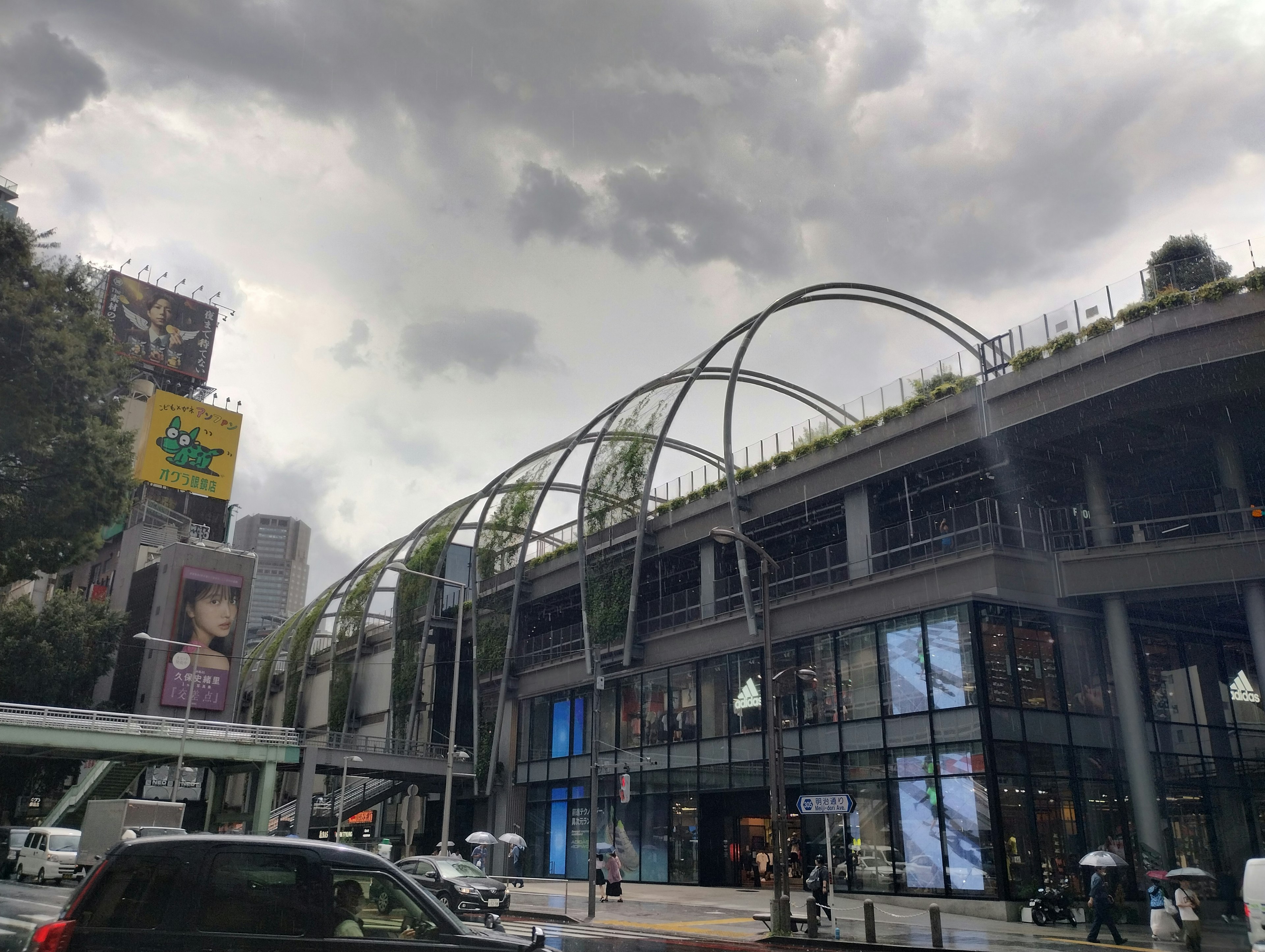 Modern building facade with distinctive arch structure and dark clouds overhead