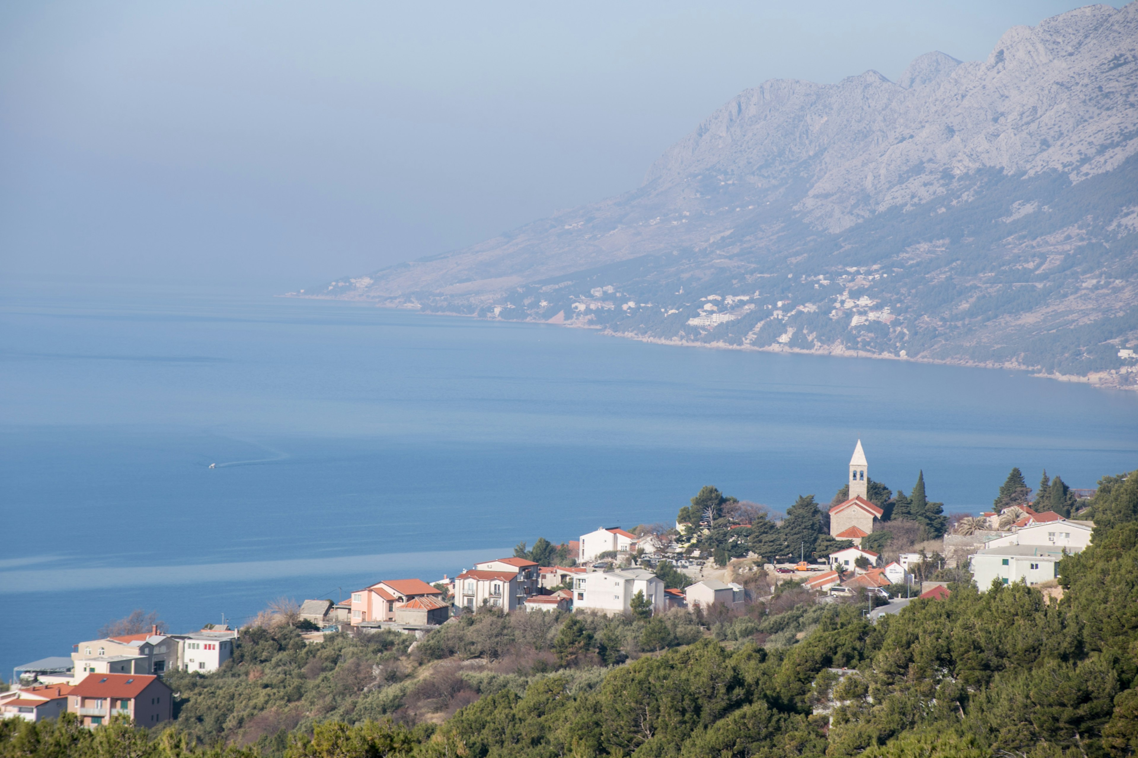 Vue côtière d'une petite ville avec des montagnes en arrière-plan