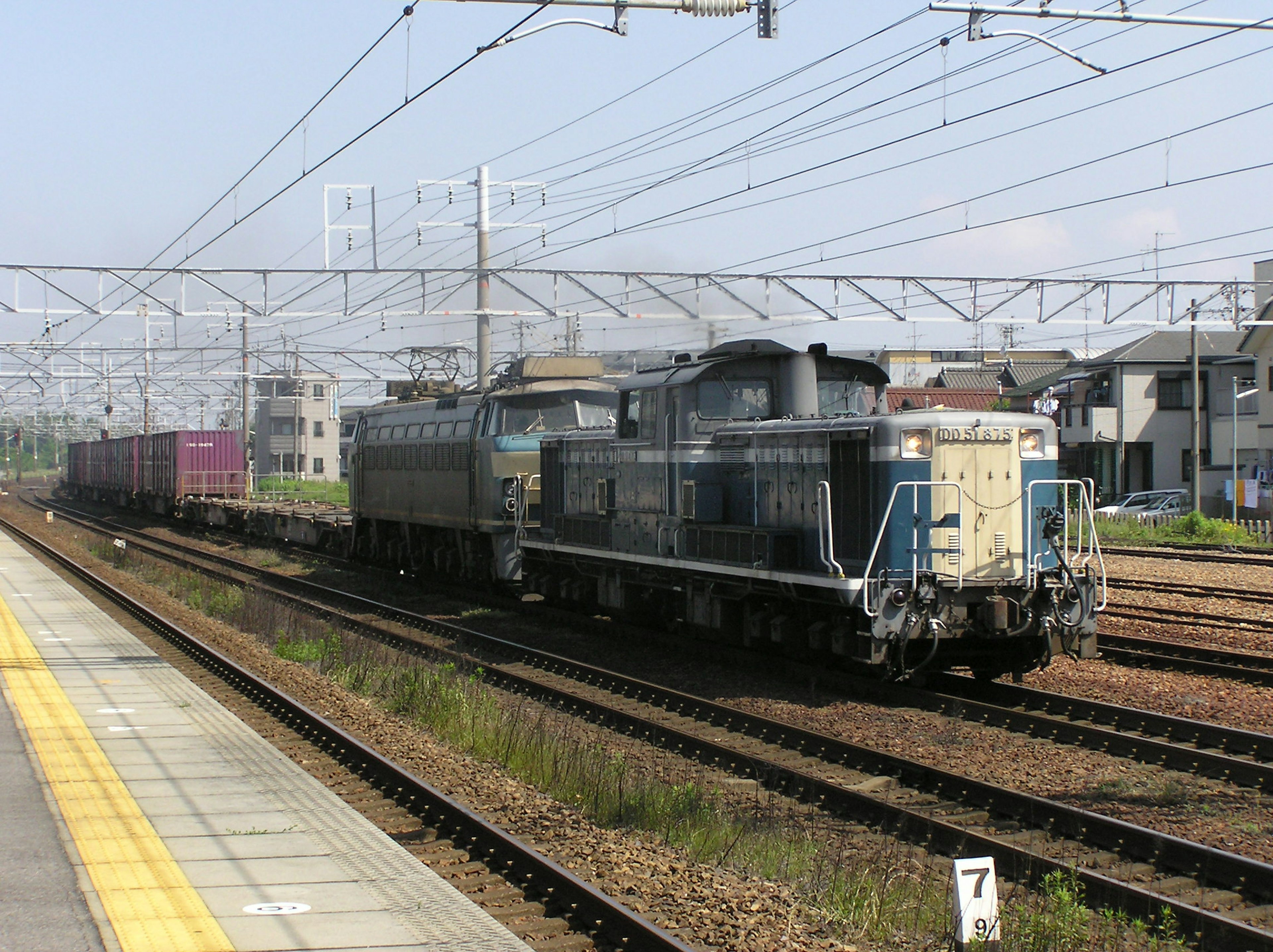 Un train de marchandises circulant sur des rails à une gare