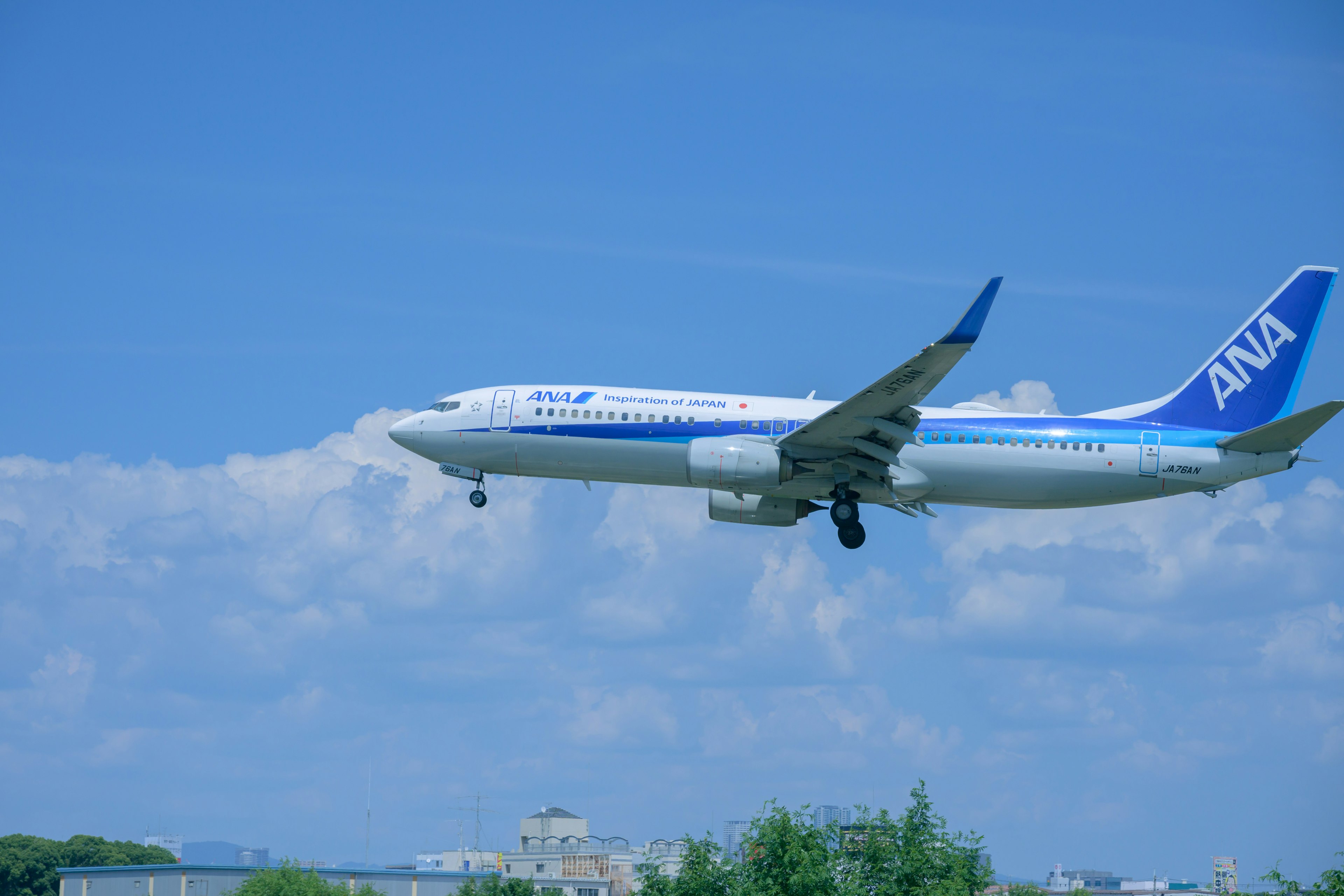 ANA Flugzeug fliegt in einem blauen Himmel mit weißen Wolken