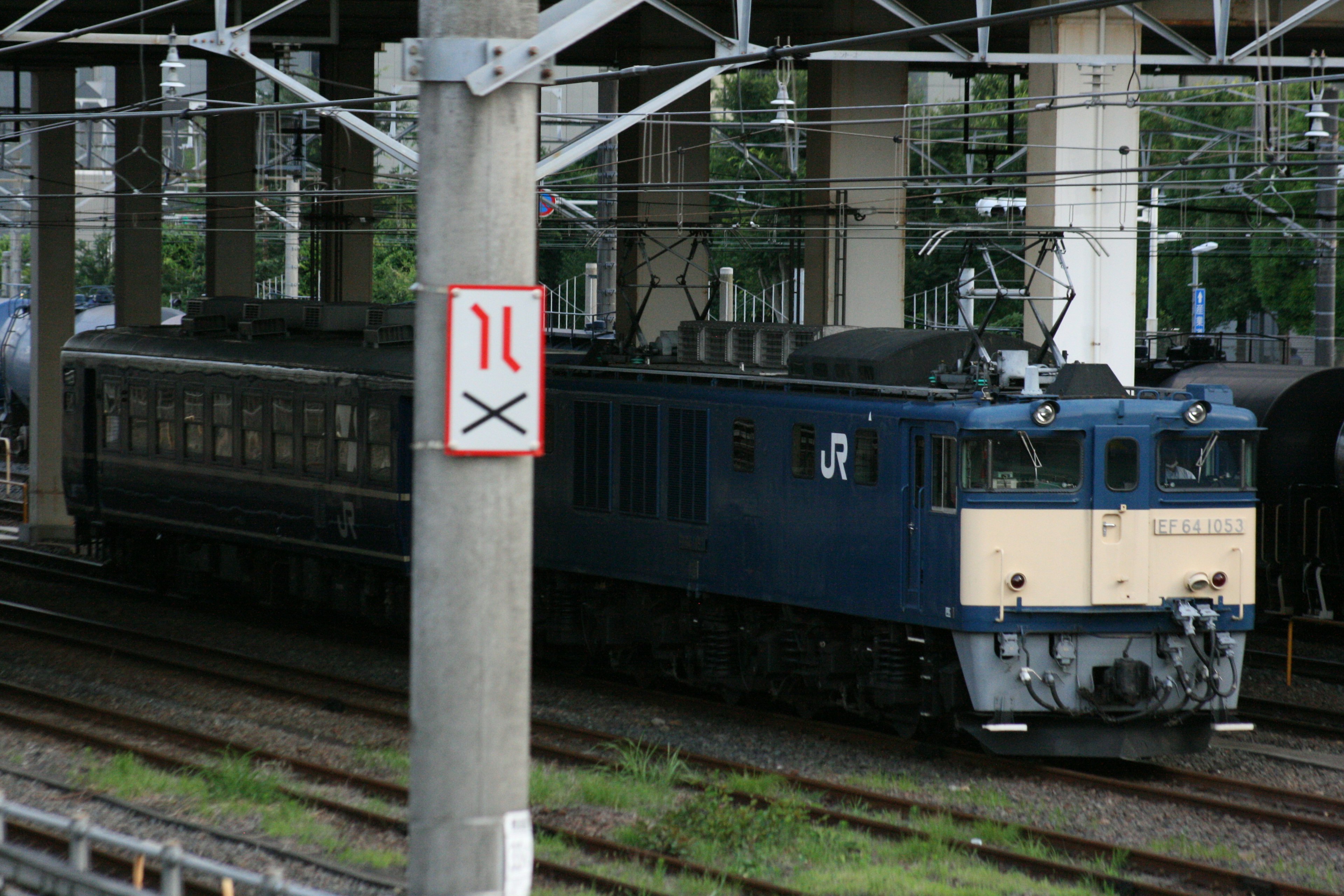 Una locomotiva blu e beige parcheggiata sui binari