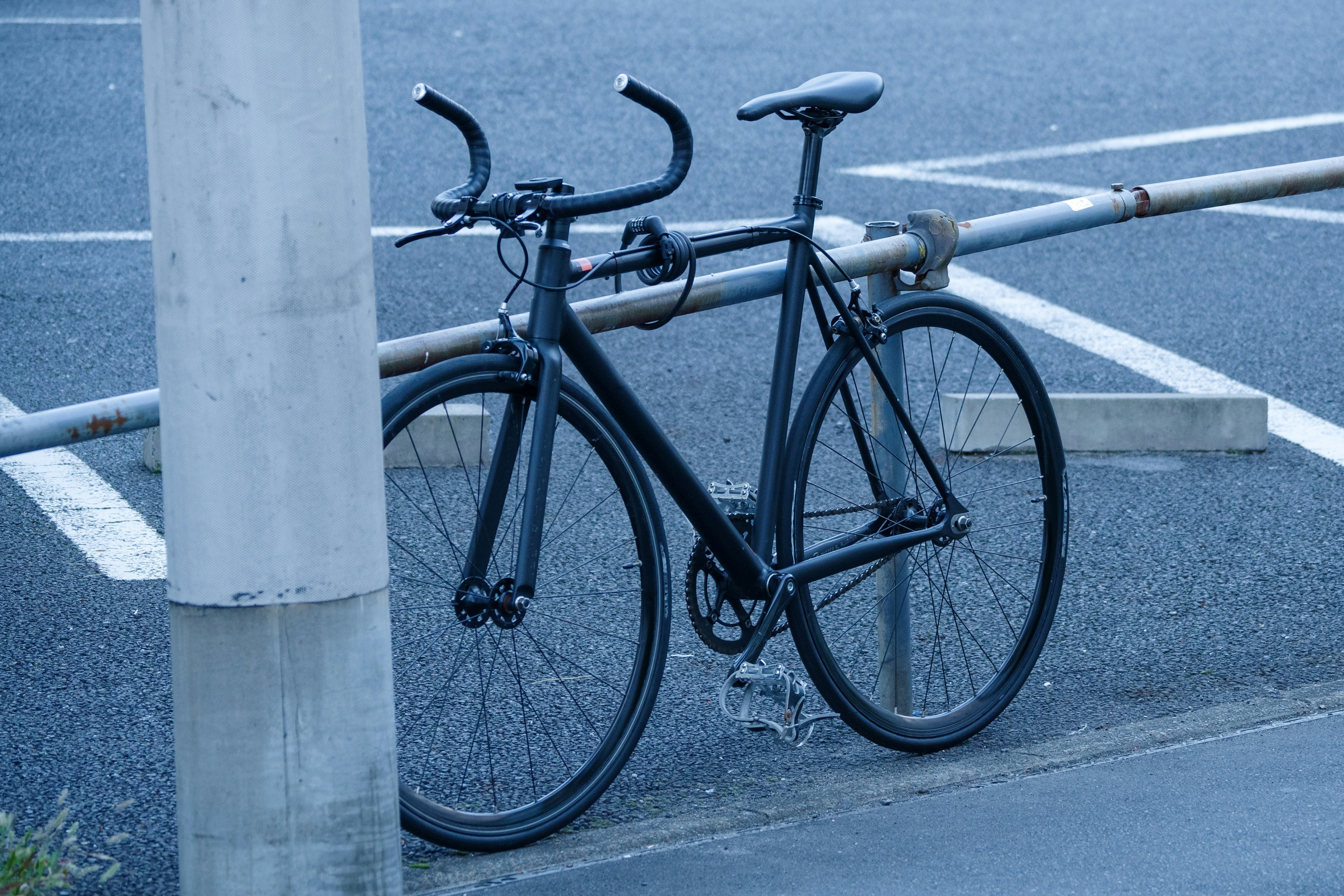 A blue-toned bicycle parked at a street corner