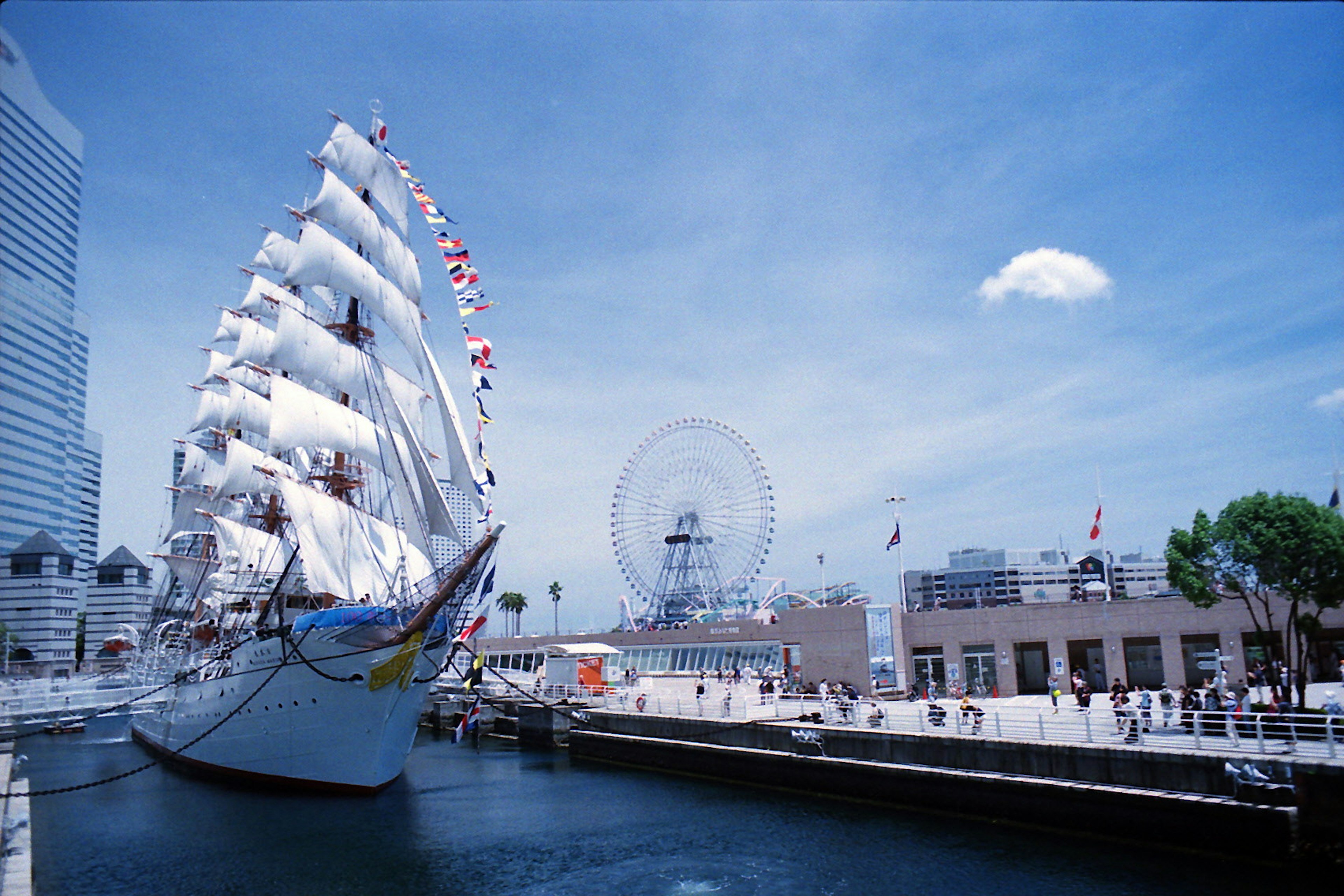 Un majestuoso barco de vela atracado en el puerto bajo un cielo azul