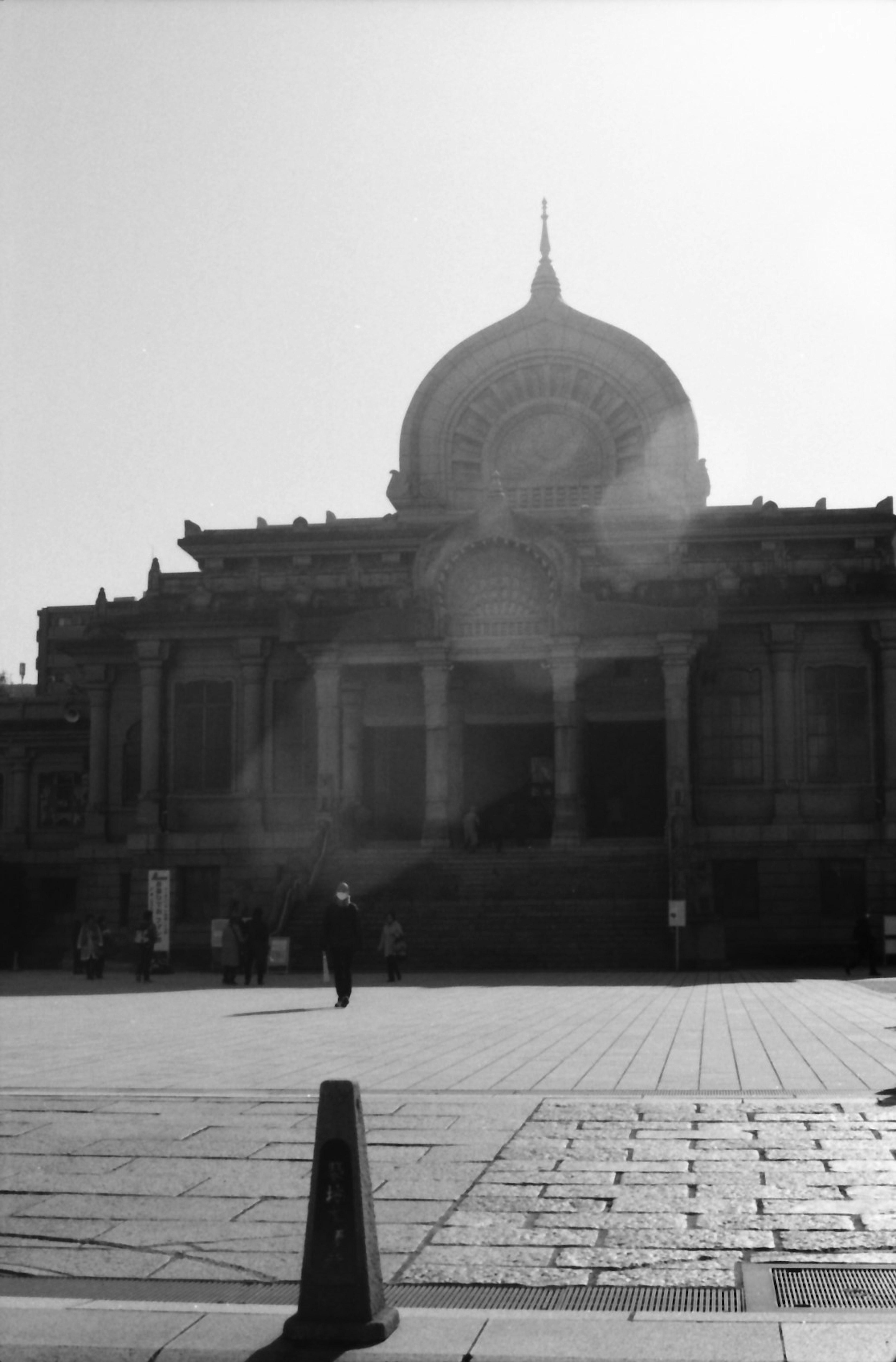 Monochrome view of a building with a large dome in a square