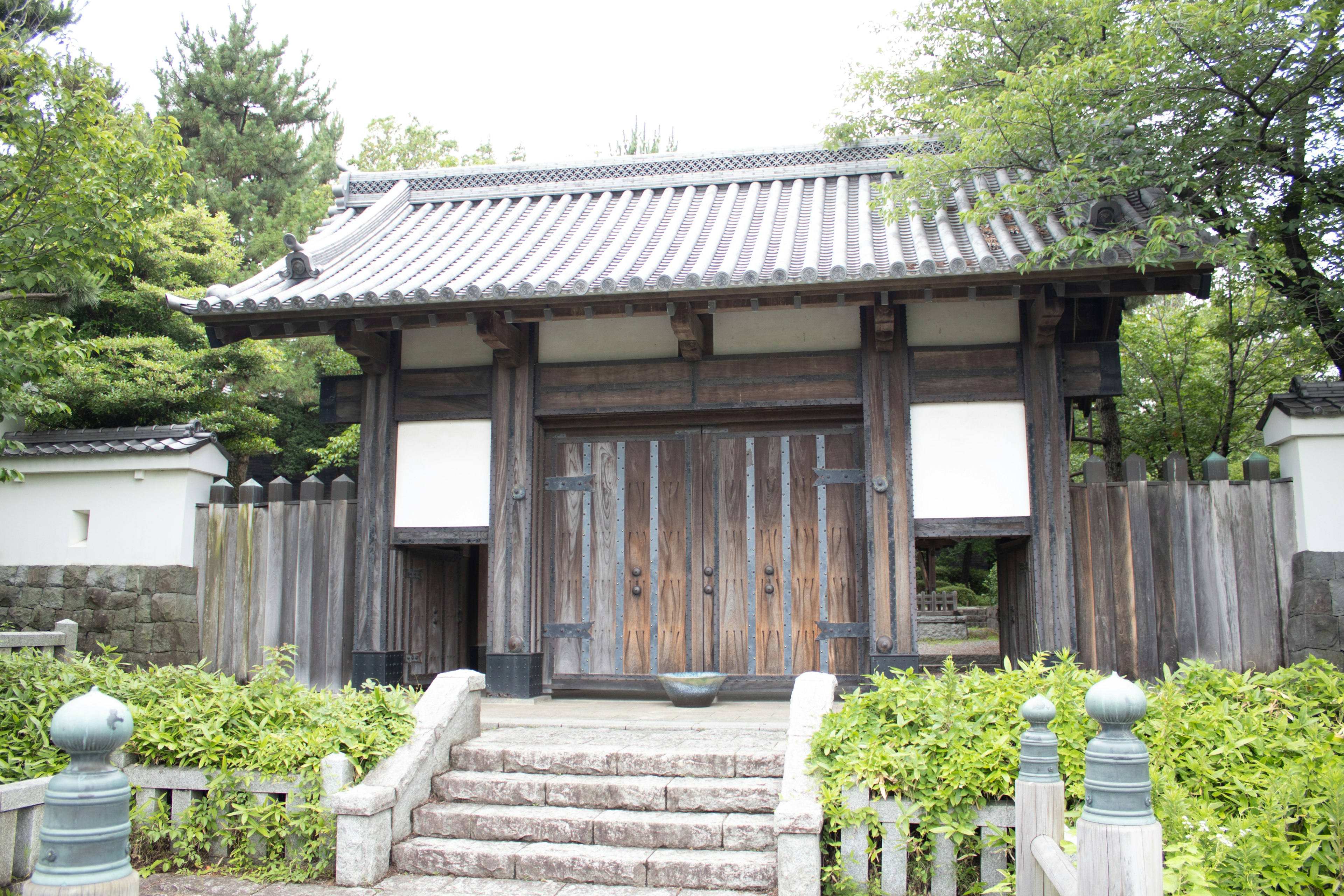 Traditional Japanese wooden gate surrounded by greenery