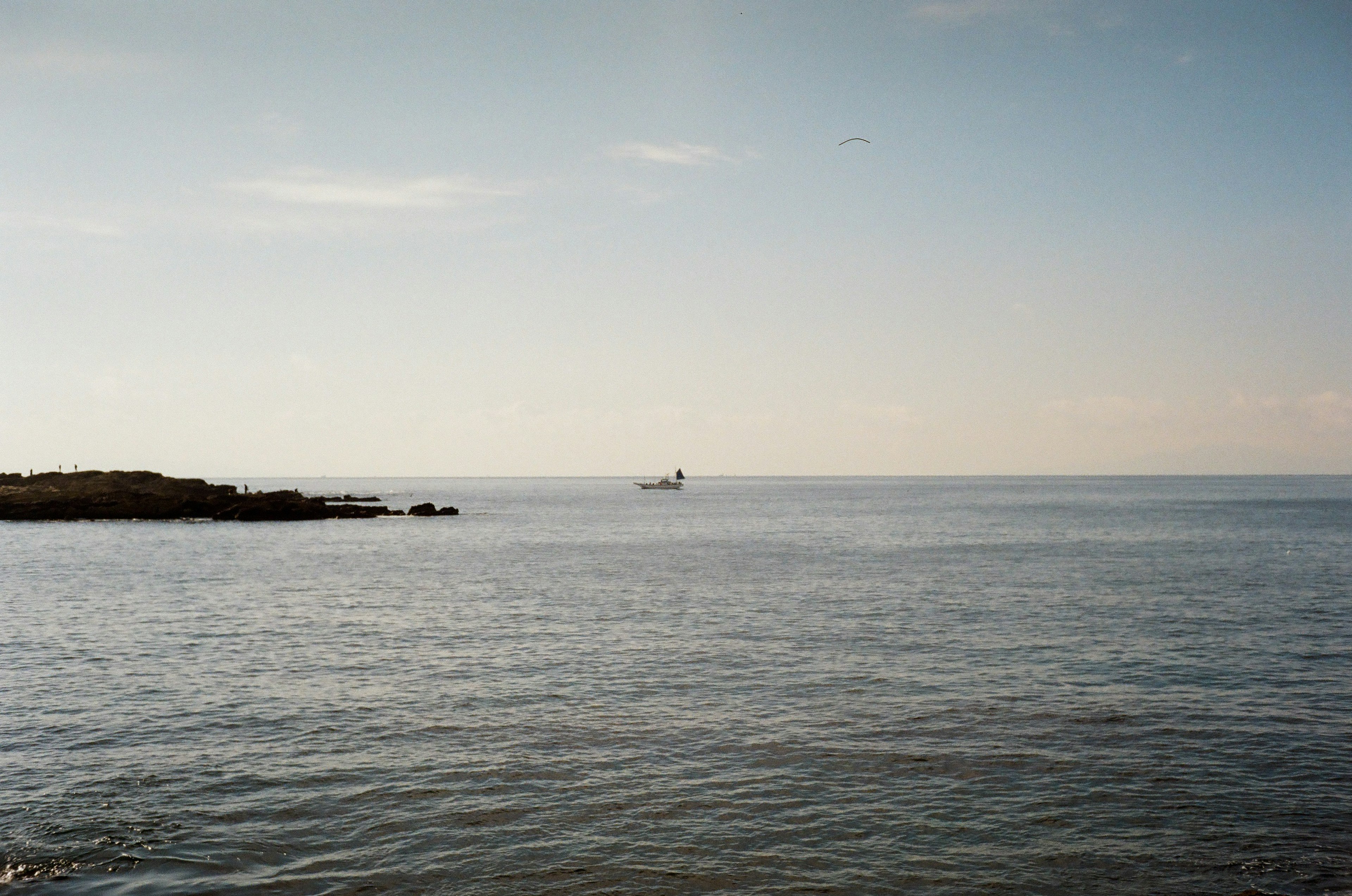 Mer calme avec un petit bateau au loin