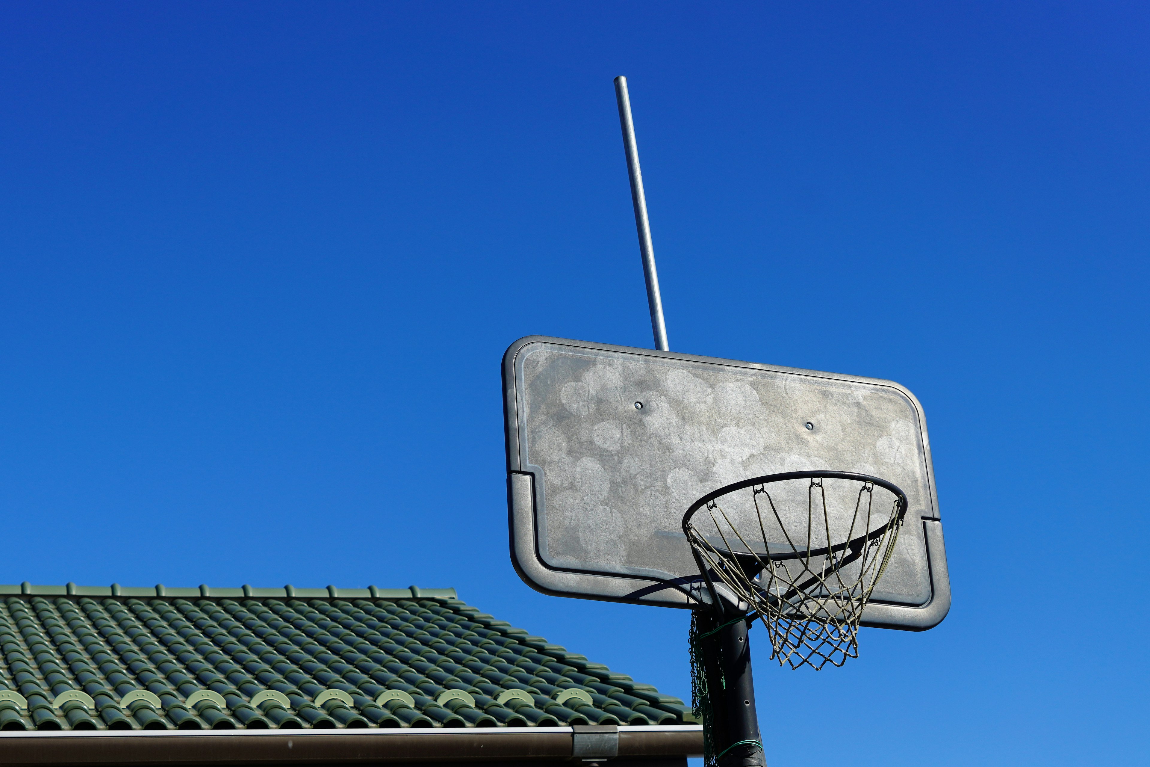 Aro de baloncesto con tablero bajo un cielo azul claro