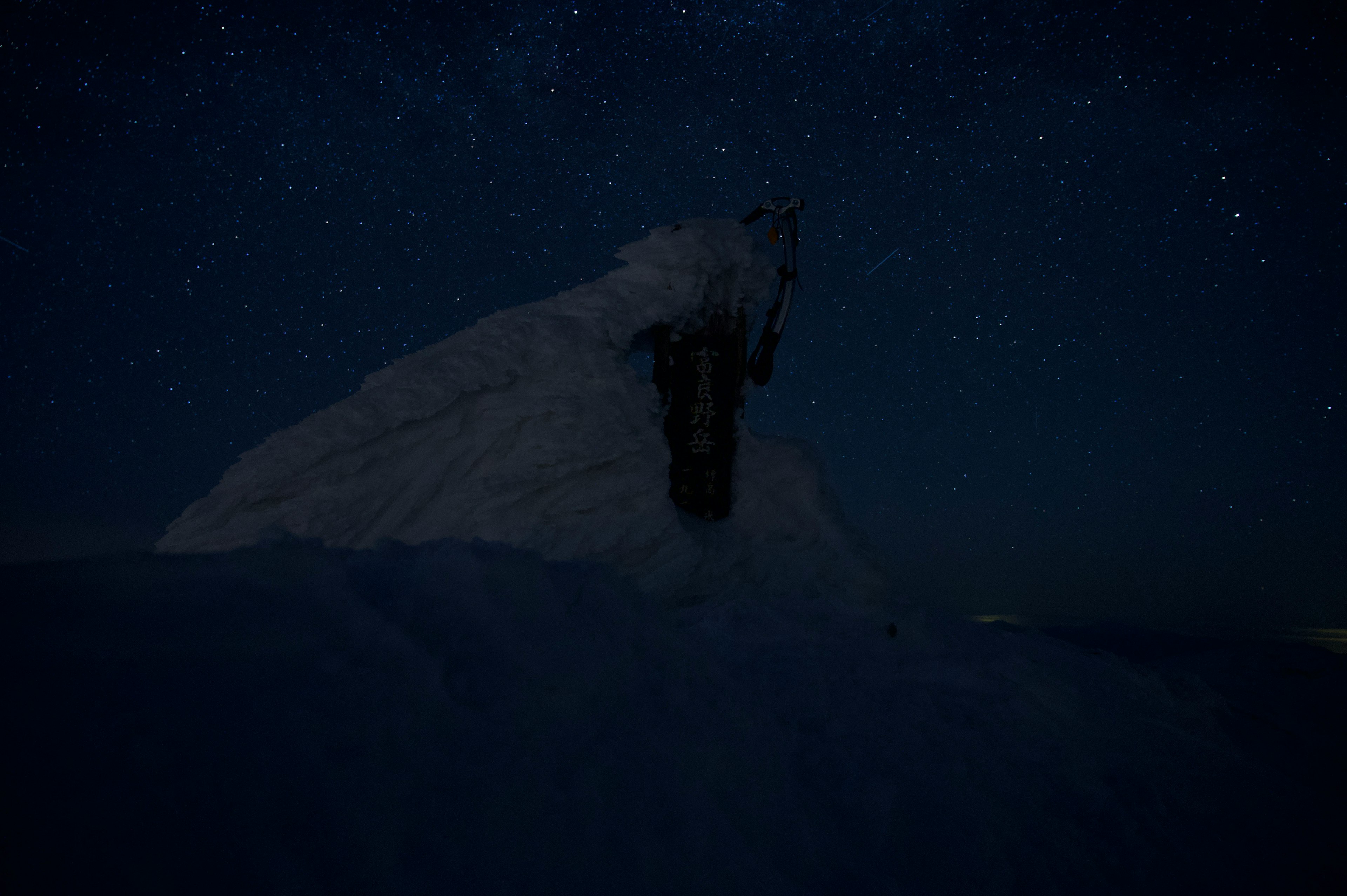 Silueta de una montaña cubierta de nieve bajo un cielo estrellado