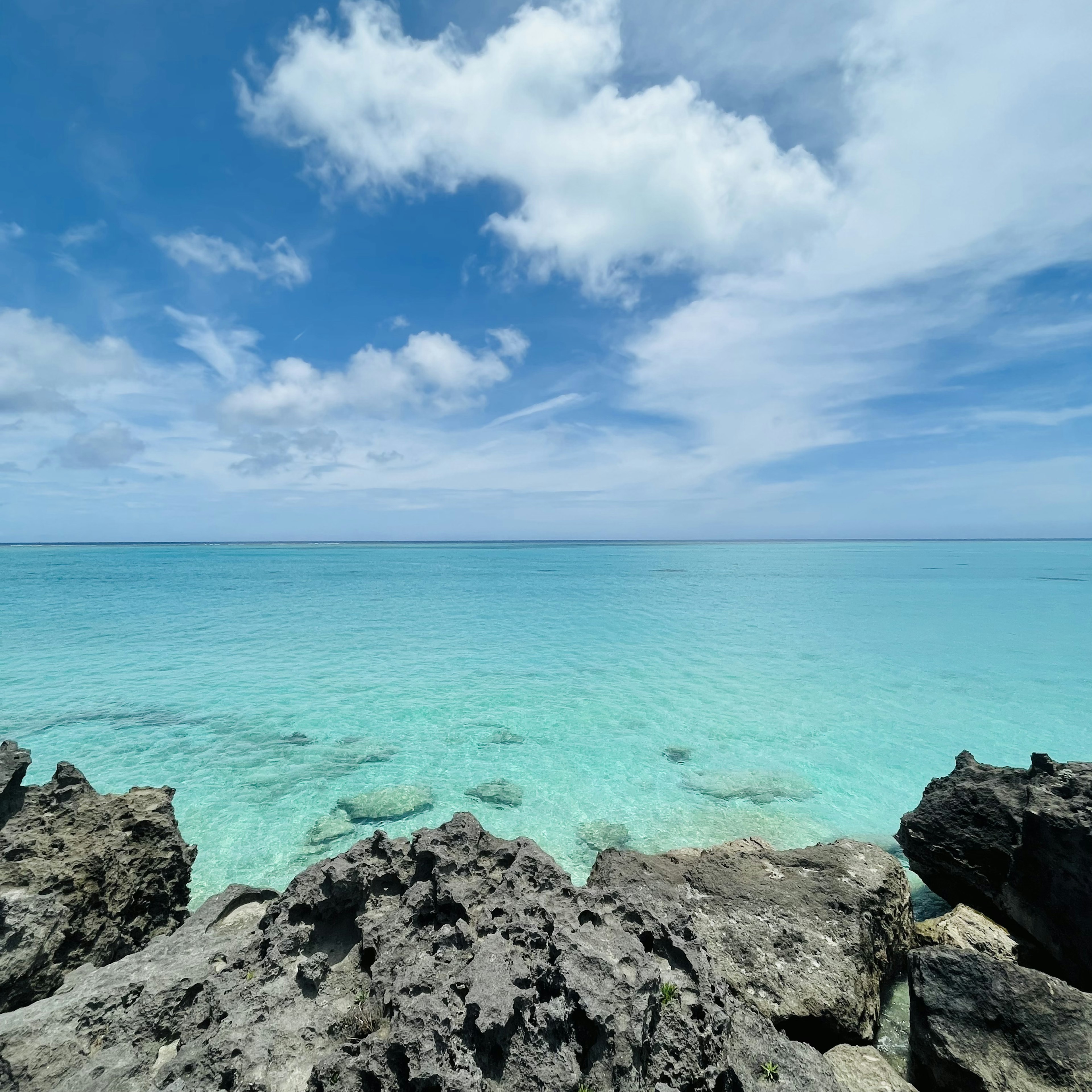 Pemandangan pantai yang indah dengan air turquoise dan awan yang tersebar