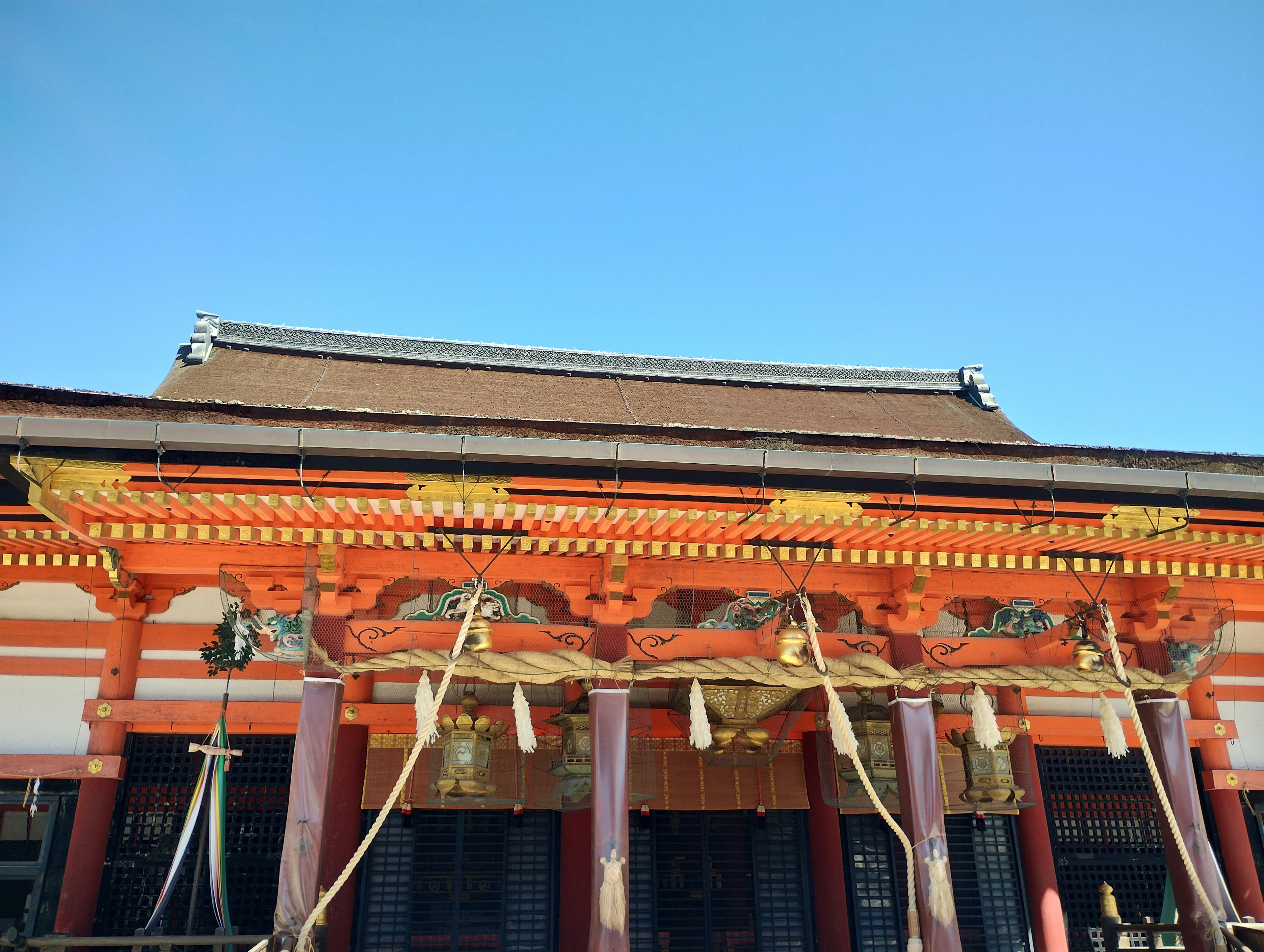 明亮的红色神社建筑在晴朗的蓝天下